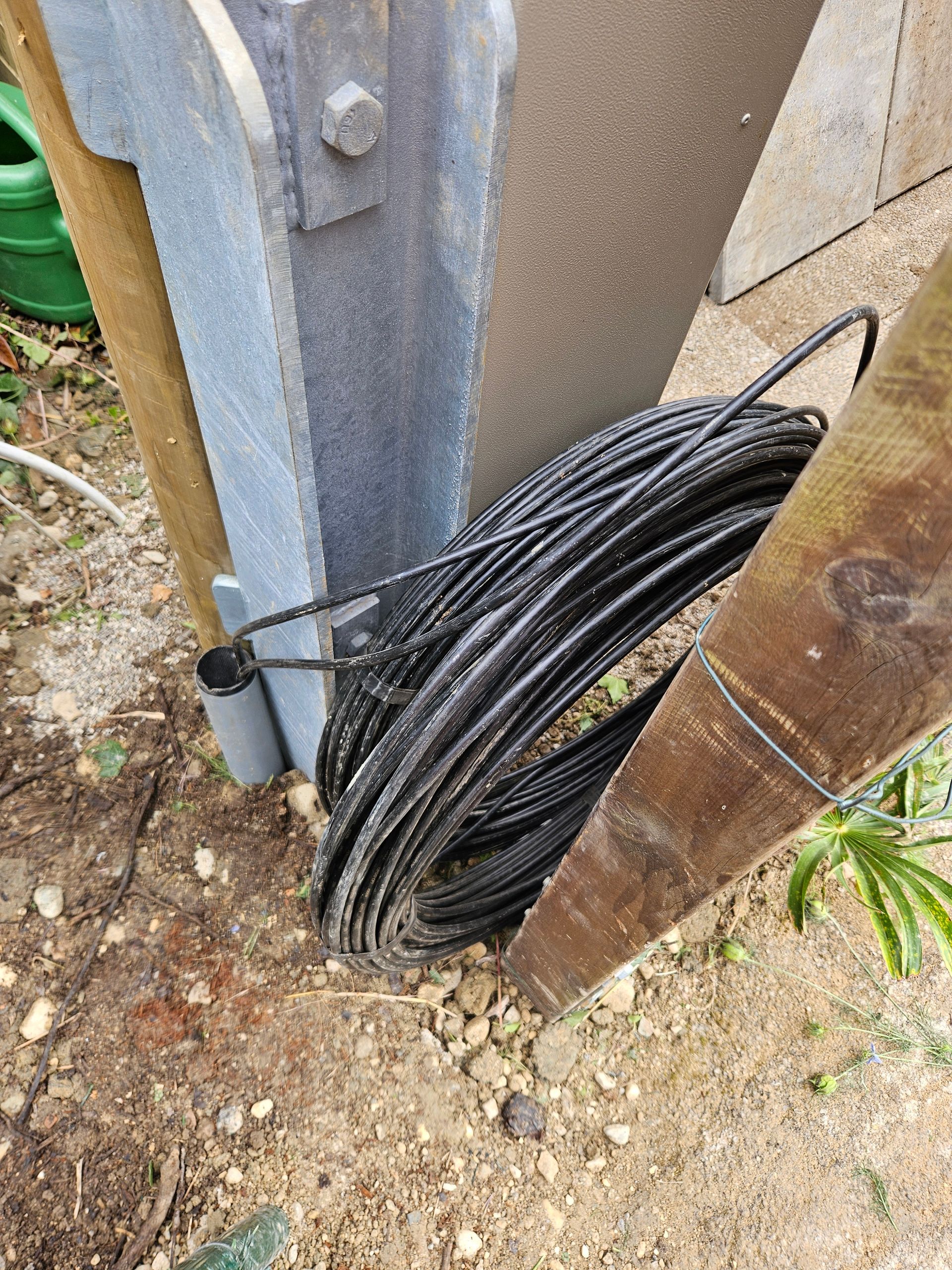 Un tas de fils posés sur le sol à côté d'un poteau