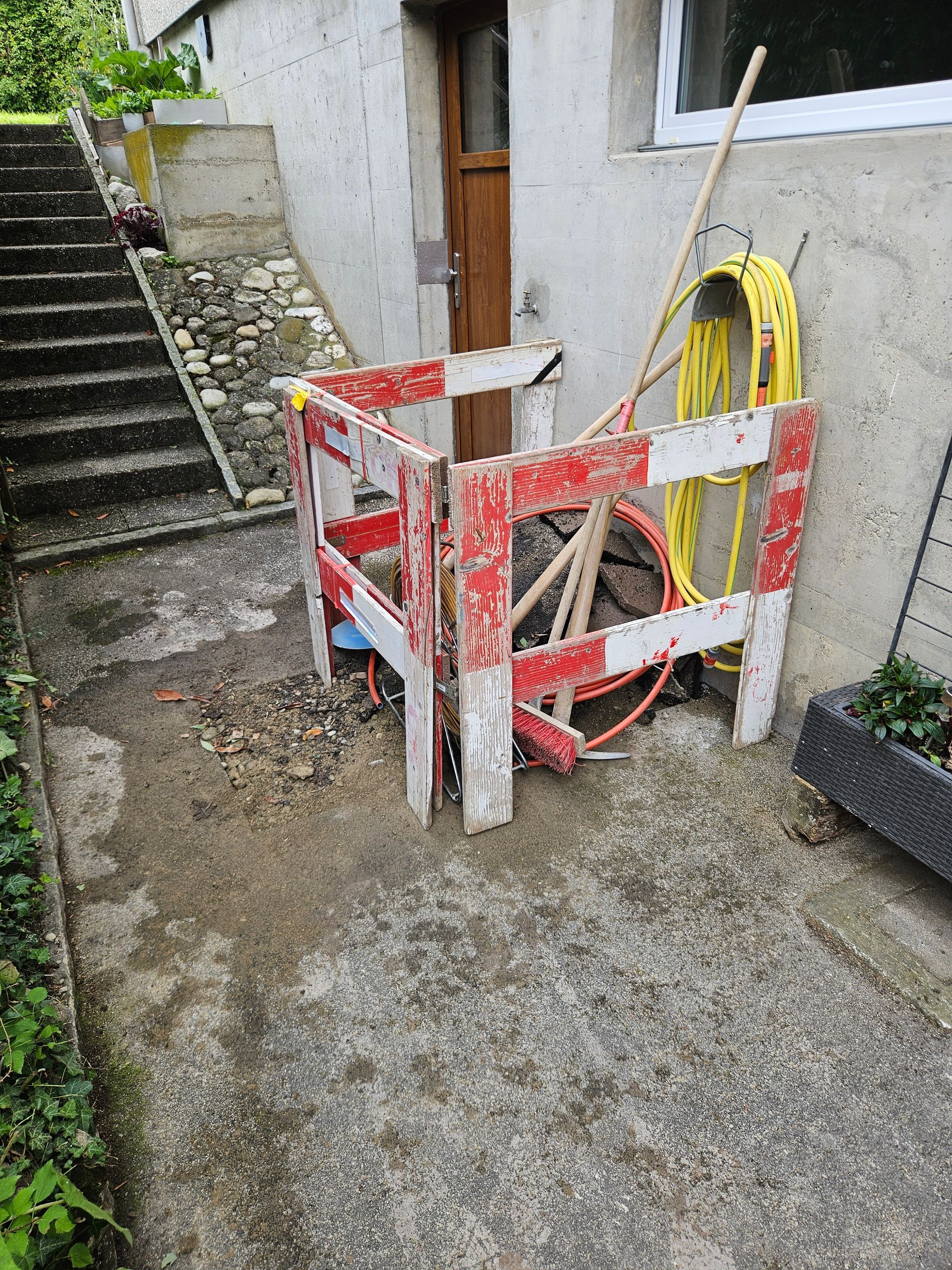 Une clôture rouge et blanche avec un tuyau jaune attaché