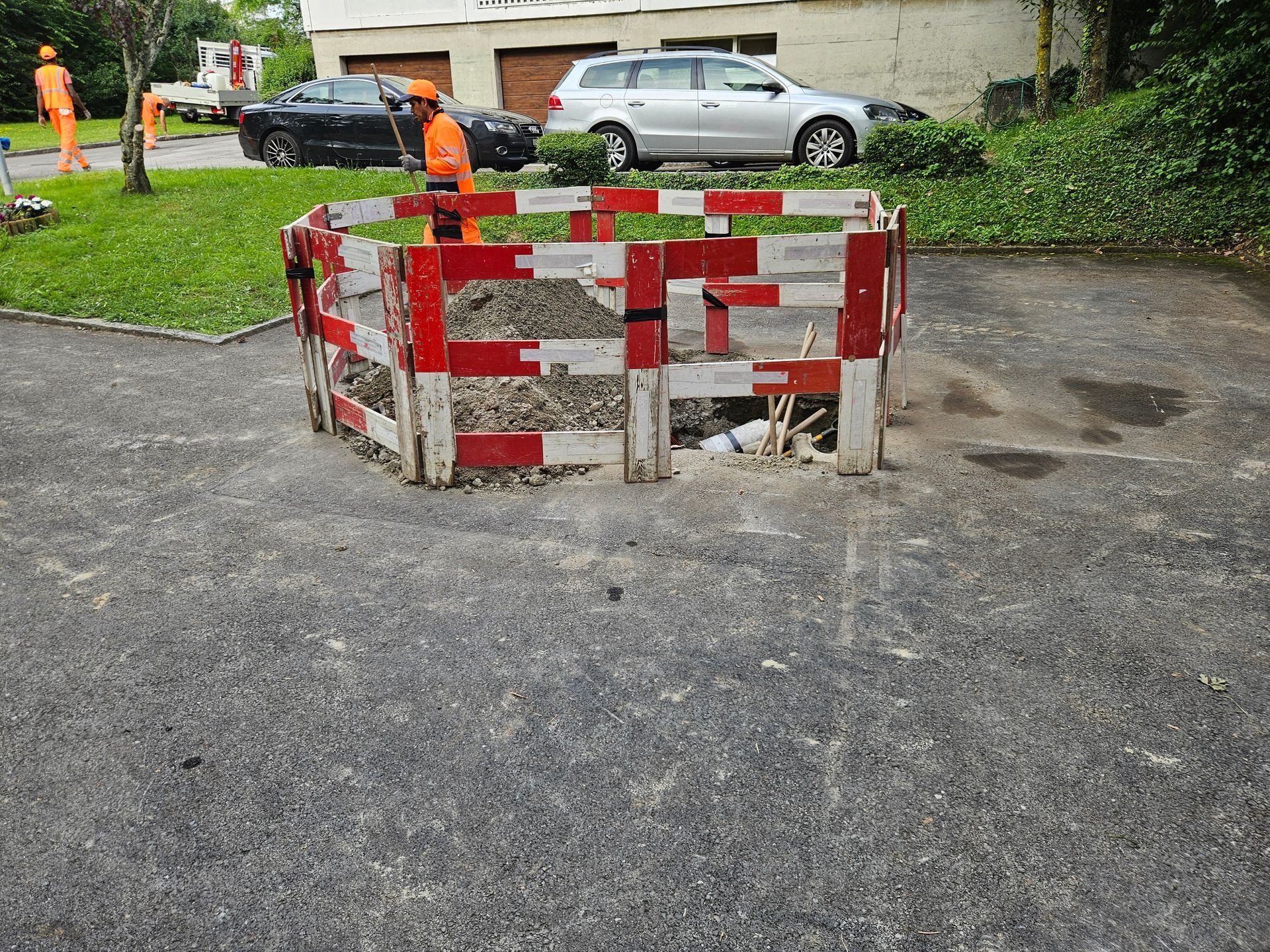 Une clôture rouge et blanche entoure un trou dans le sol