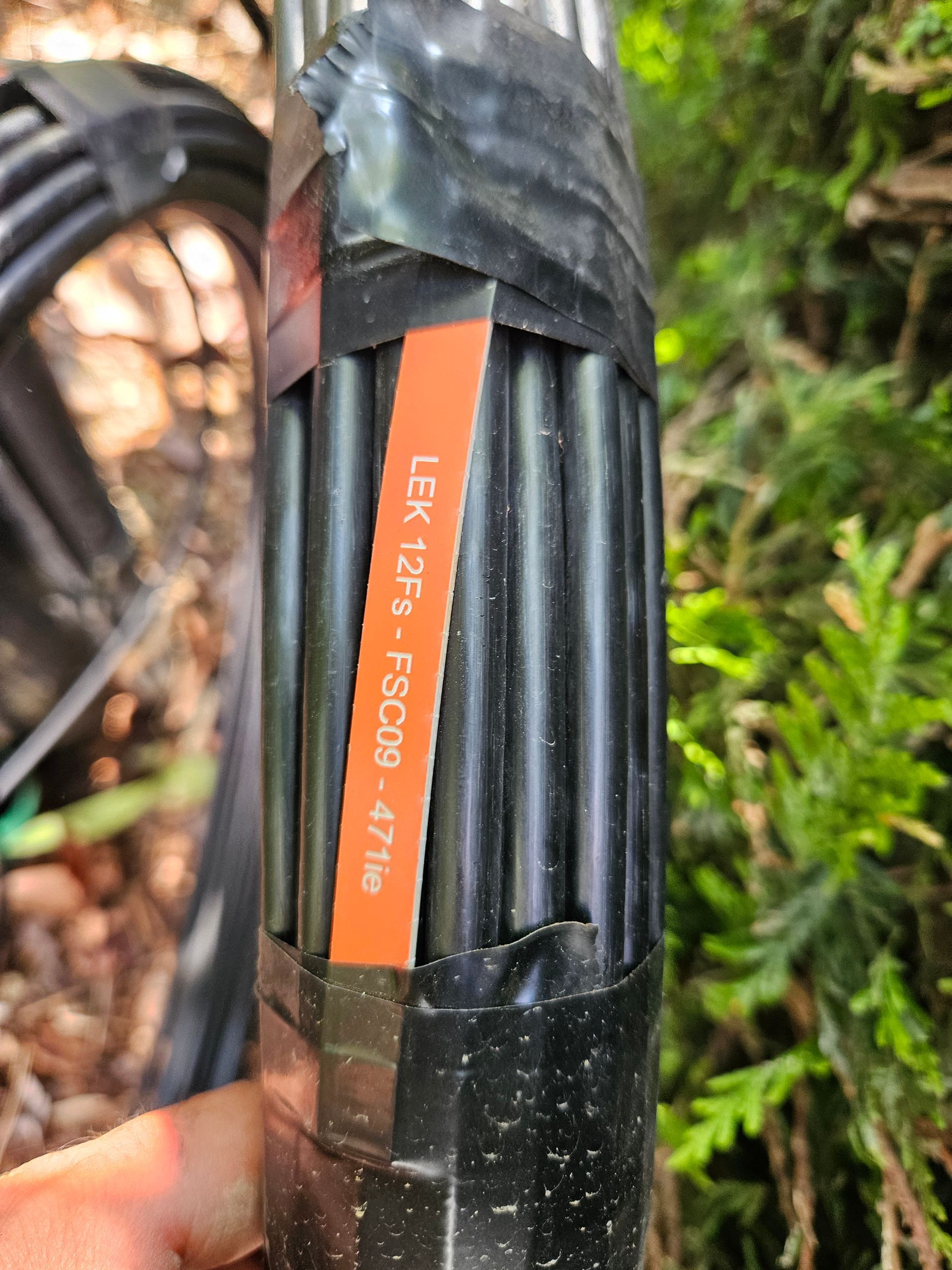 Une personne tient un morceau de ruban adhésif sur lequel est écrit fuite