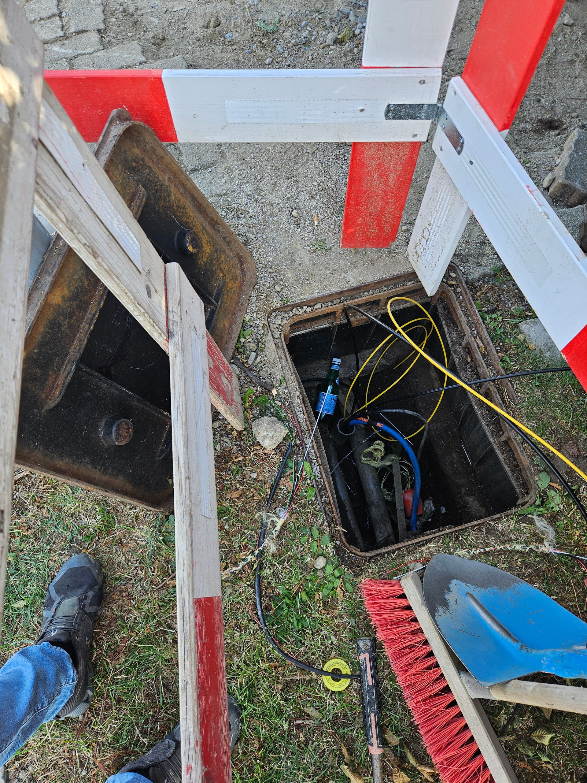 Un couvercle de trou d'homme avec une brosse et une pelle à l'intérieur