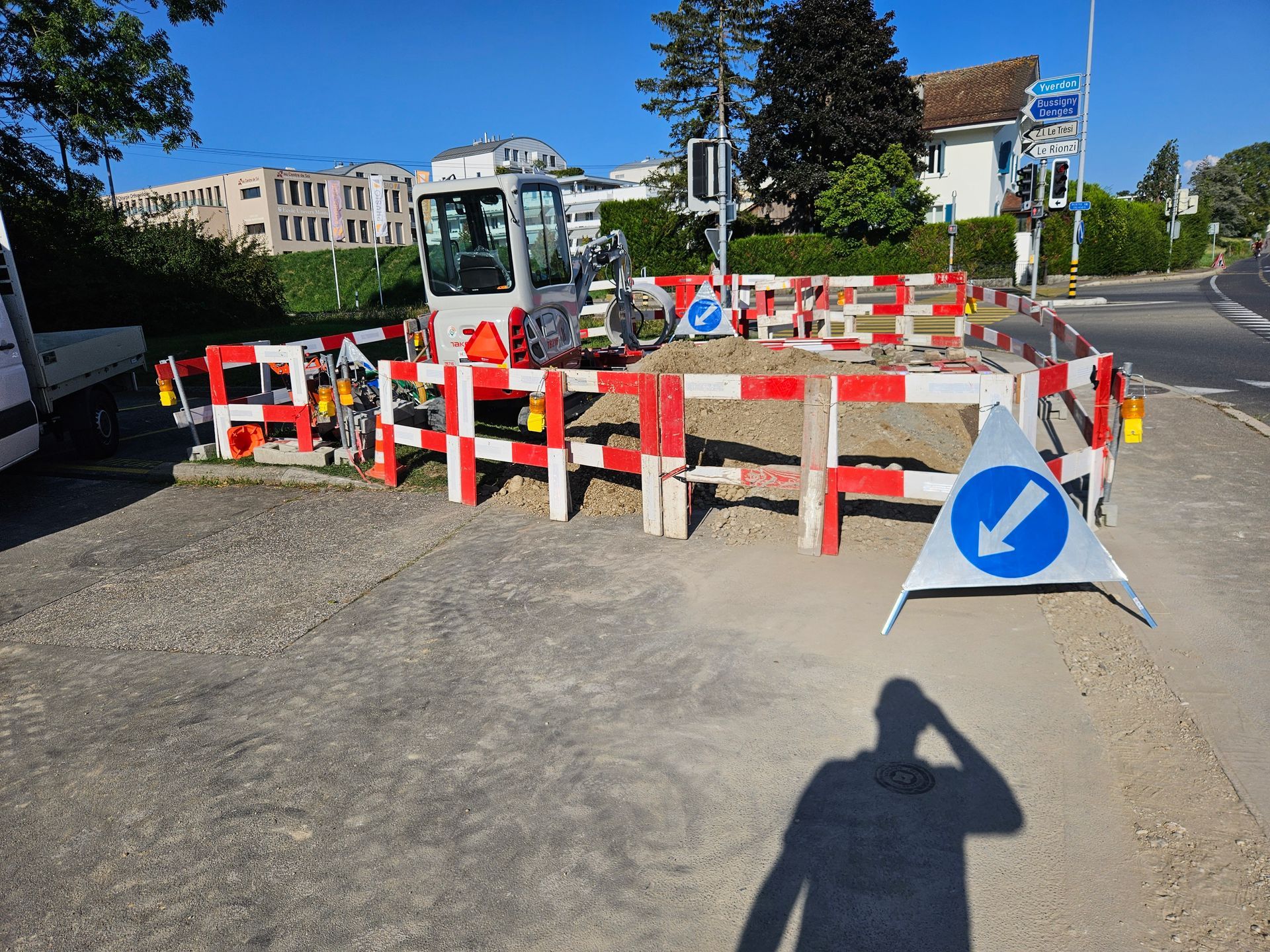 L'ombre d'une personne est projetée sur le sol devant un chantier de construction