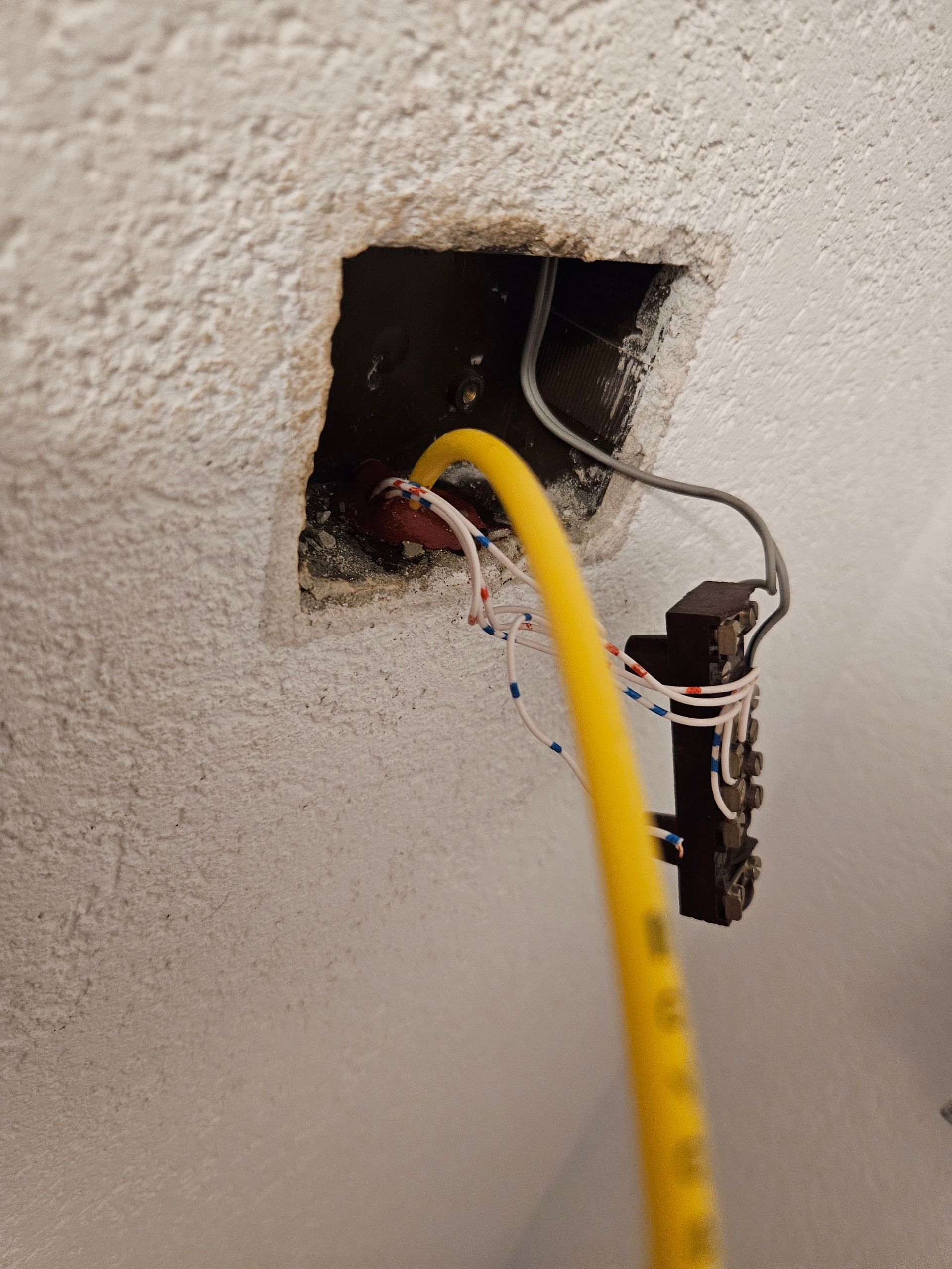 Un câble jaune est branché sur une prise murale