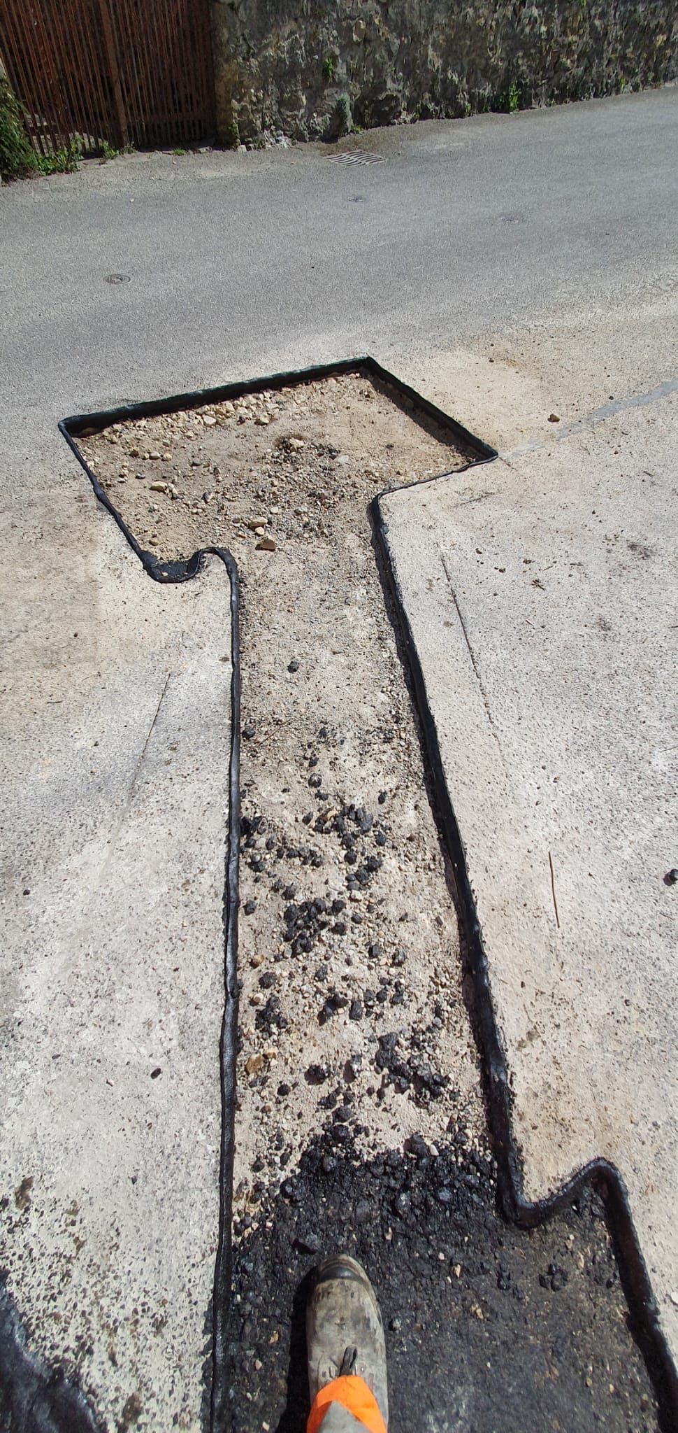 Une personne utilise une pelle pour creuser un trou dans le sol en forme de flèche