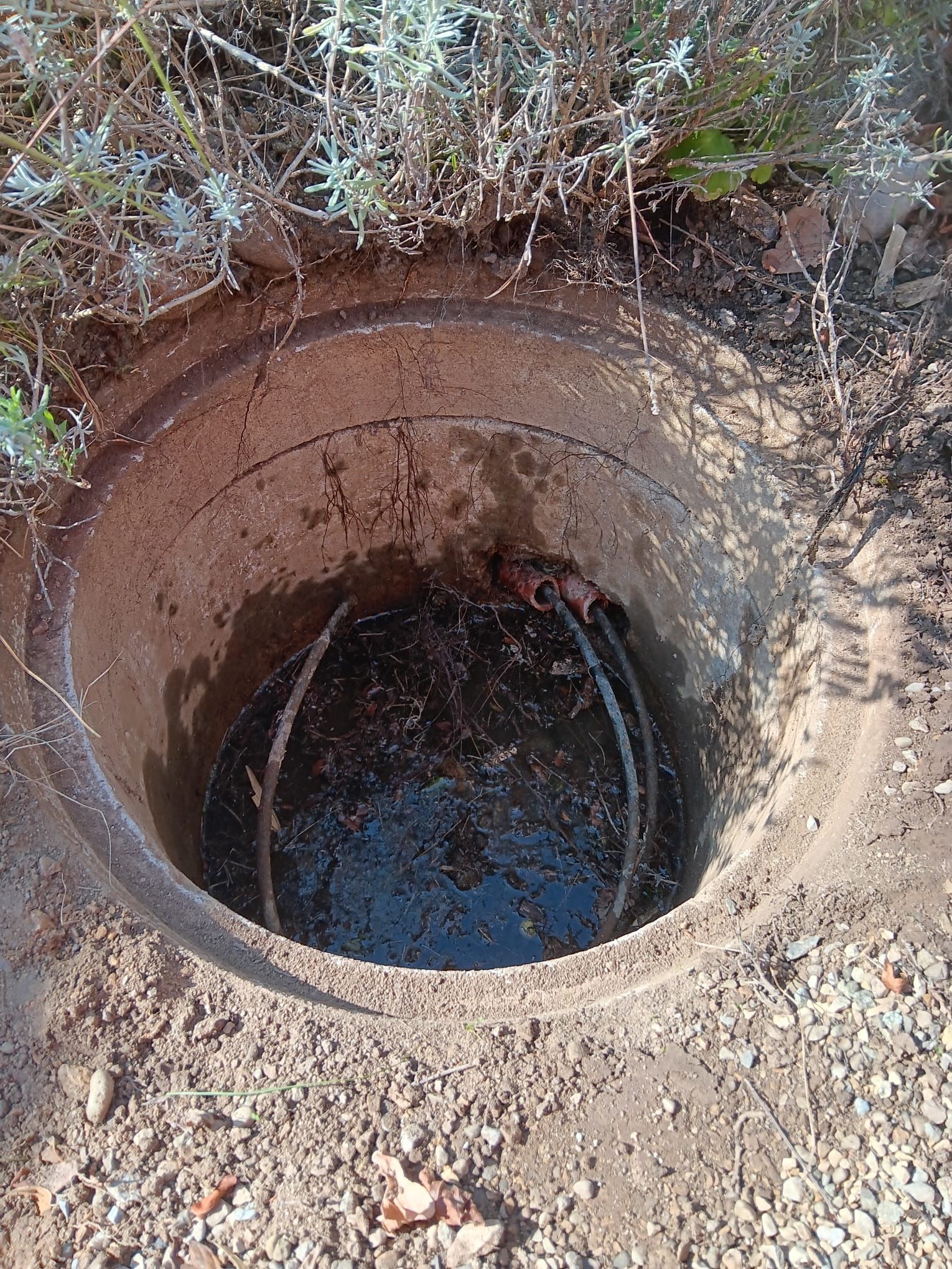 Un trou dans le sol d'où sort de l'eau