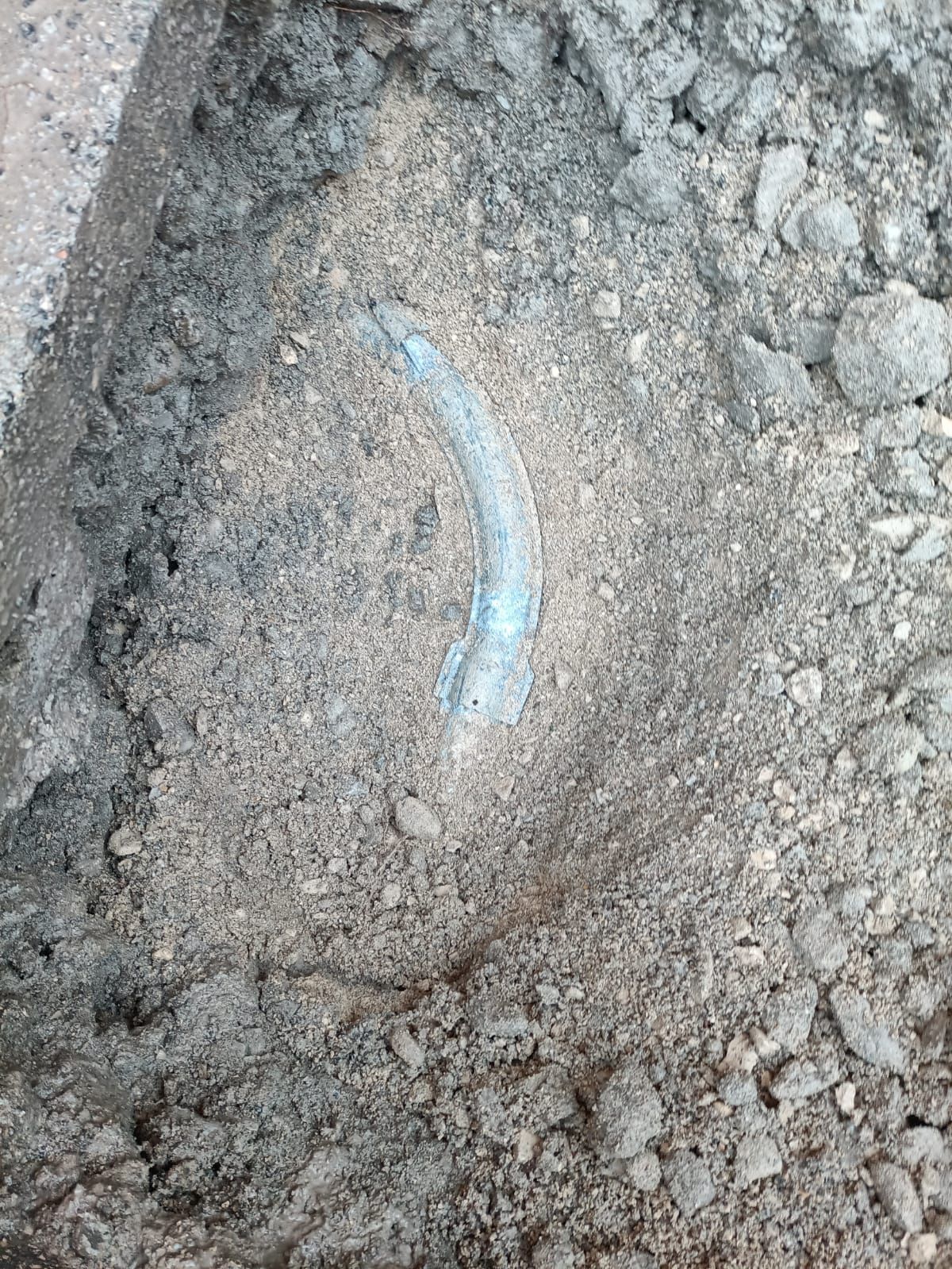 Un gros plan d'un tas de terre avec un objet bleu au milieu.