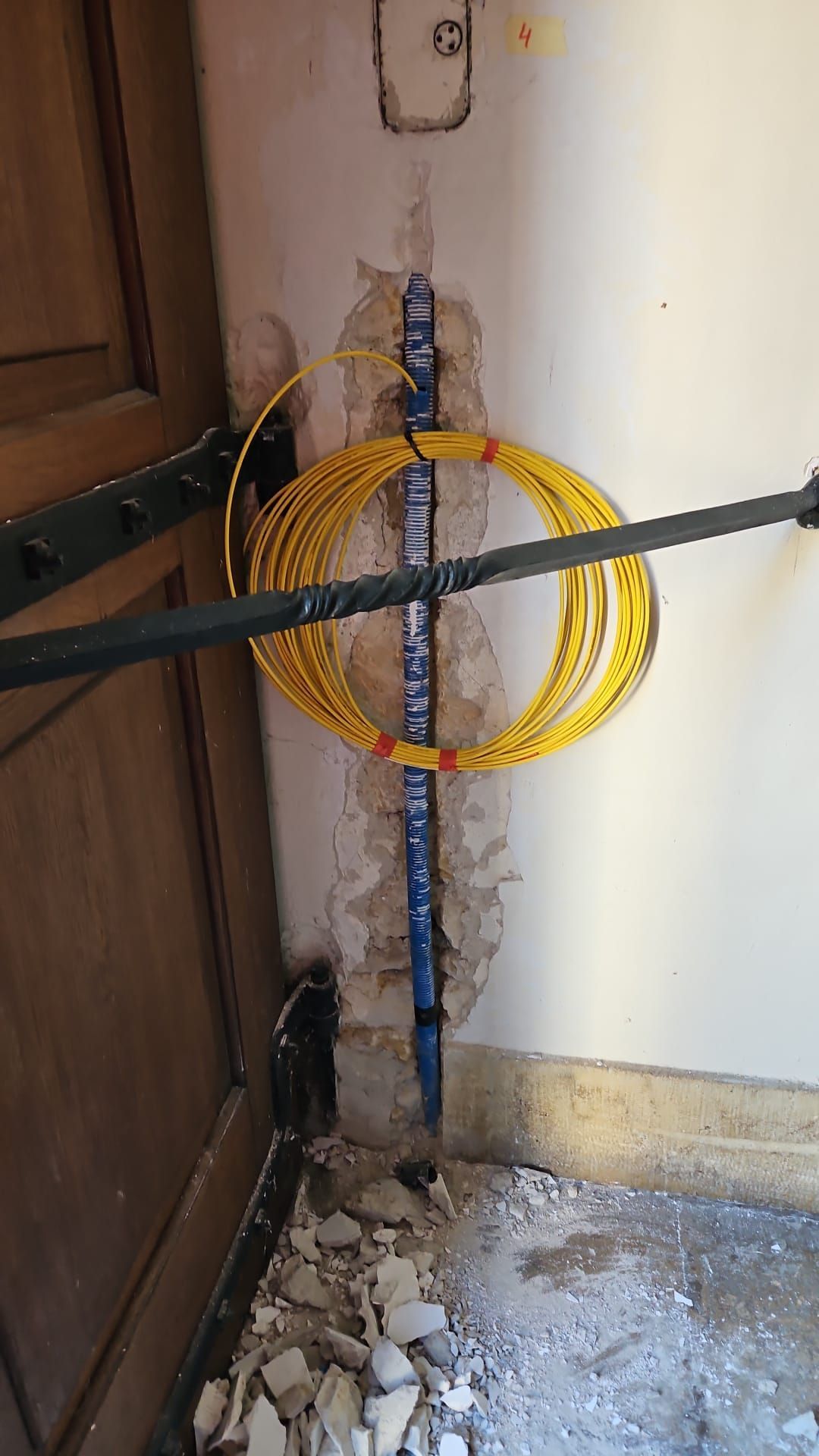 Un tuyau jaune est suspendu à un poteau métallique dans une pièce