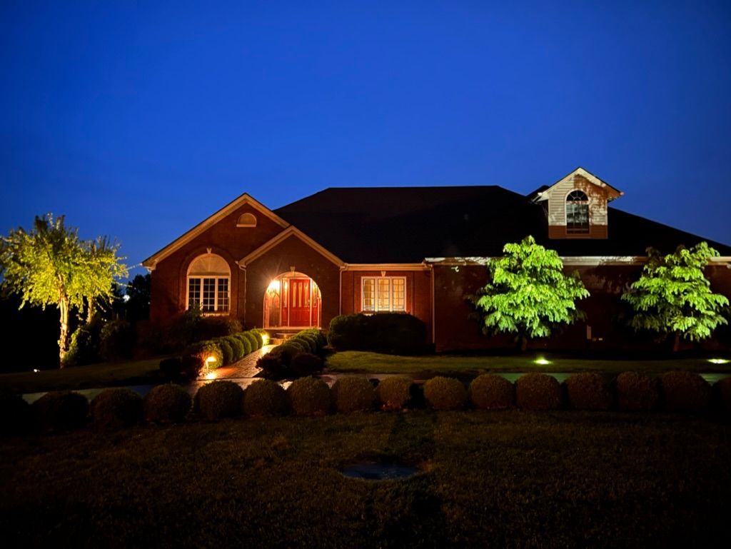 A large brick house is lit up at night