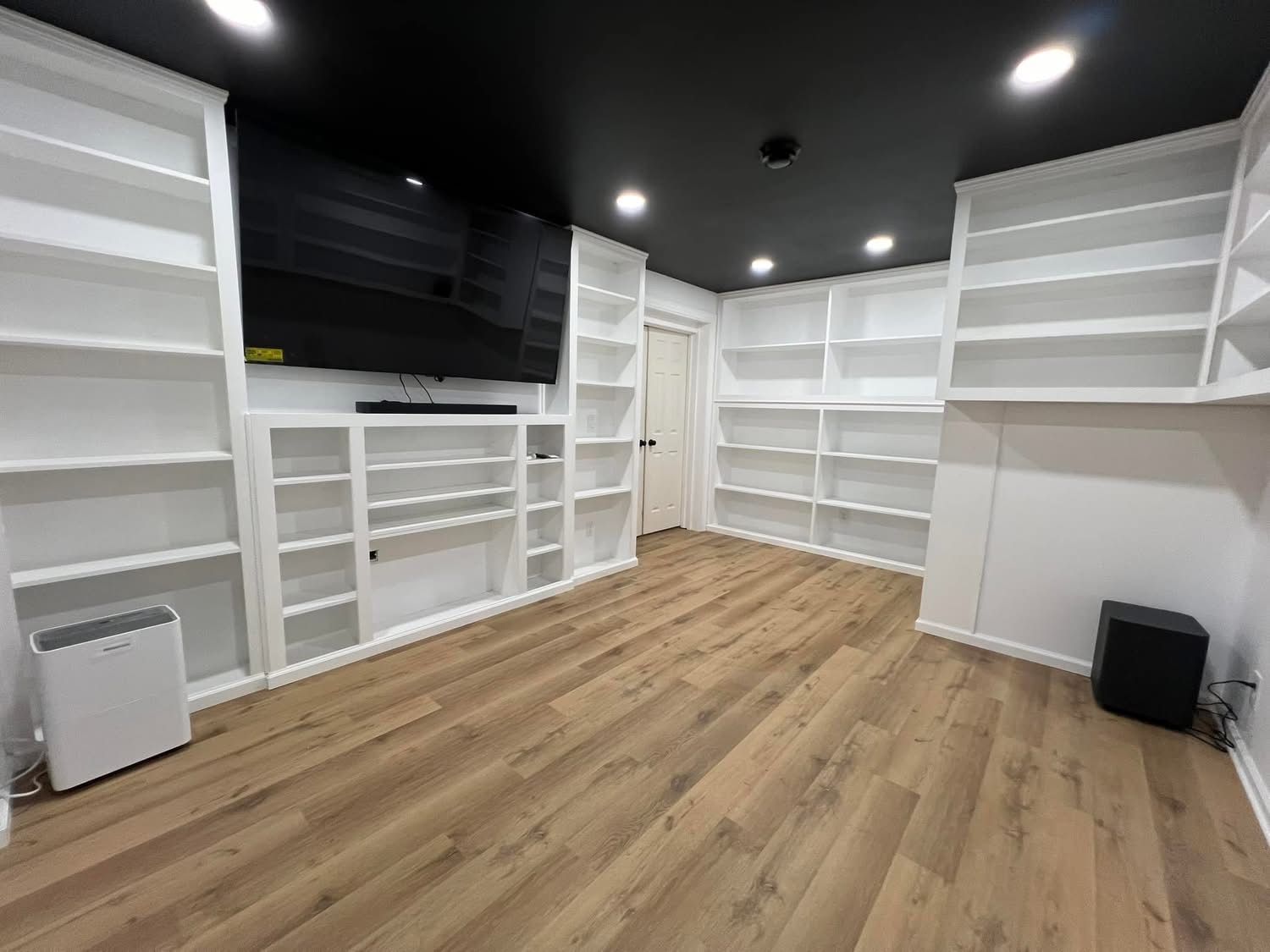 A large room with lots of shelves and a black ceiling.