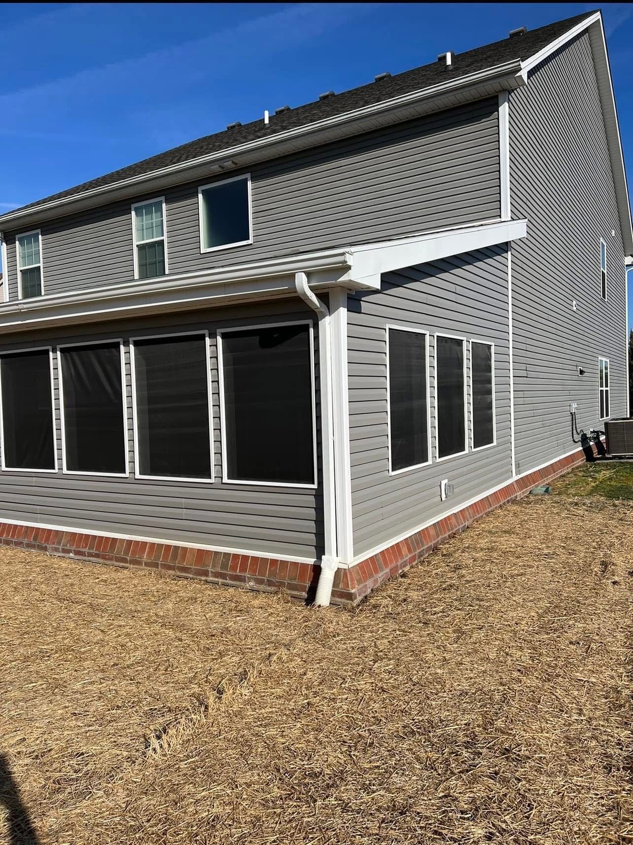 A large house with a lot of windows and a screened in porch.