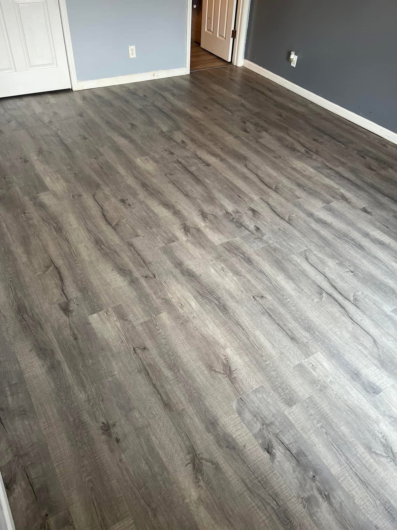 A living room with a wooden floor and gray walls.