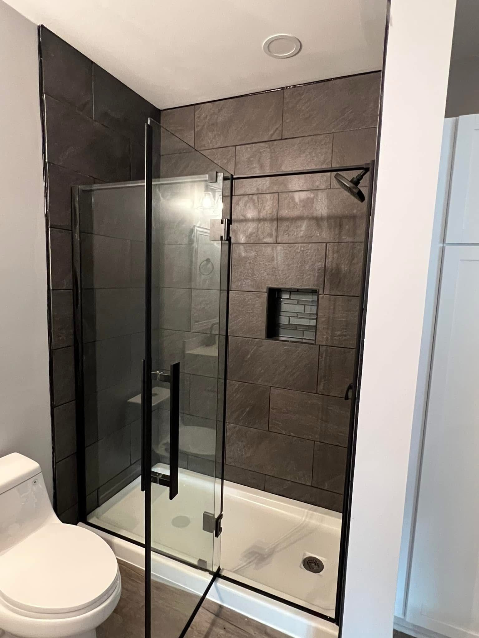 A bathroom with a toilet and a walk in shower.