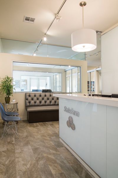 A waiting room with a couch and chairs and a reception desk.