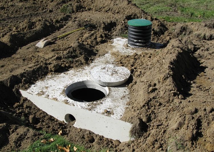 A septic tank is being built in a dirt field