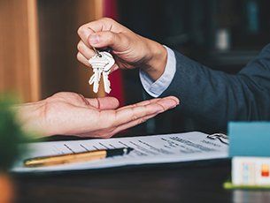 Real Estate — Man Handing Keys to Client in Lake City, FL