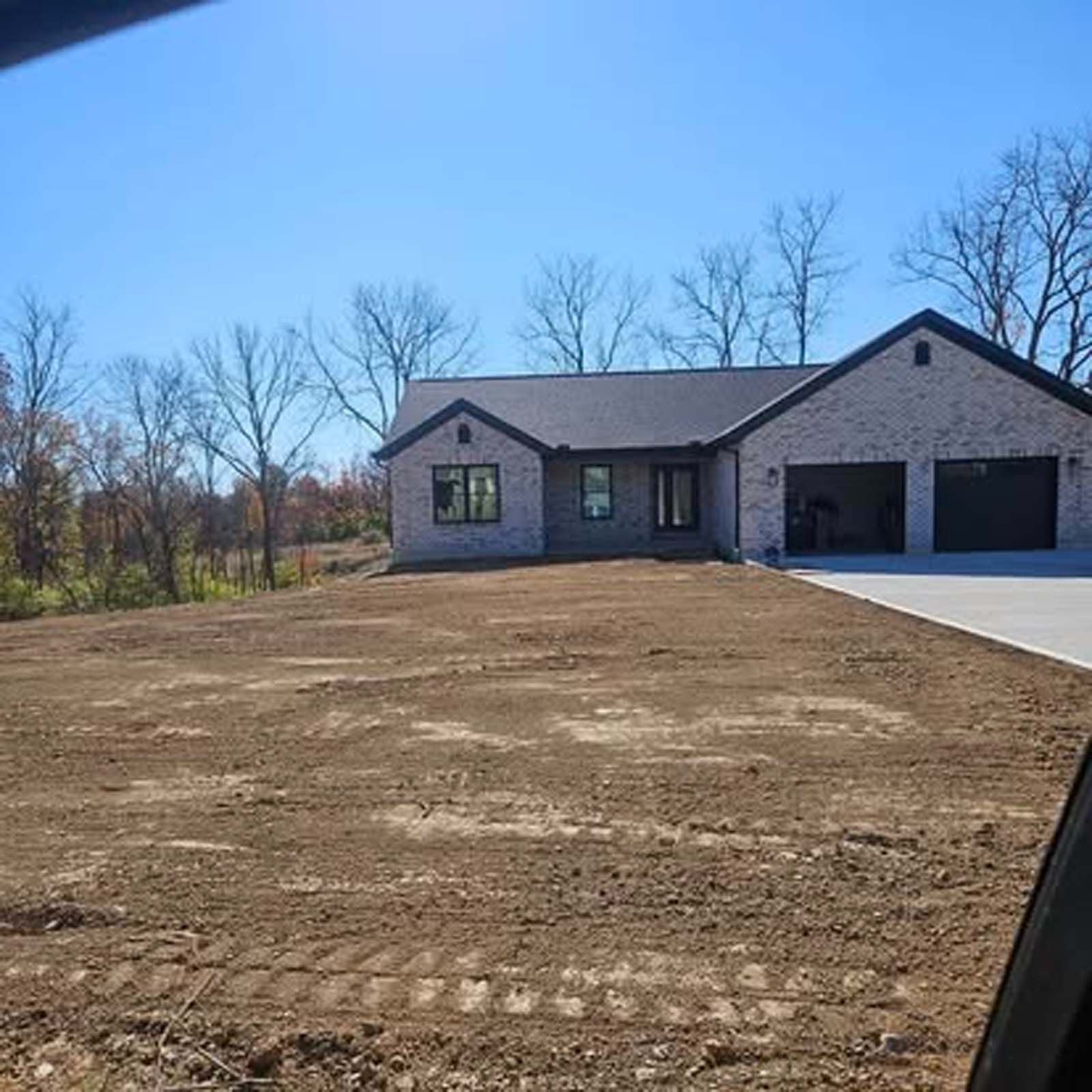 A house is sitting in the middle of a dirt field.