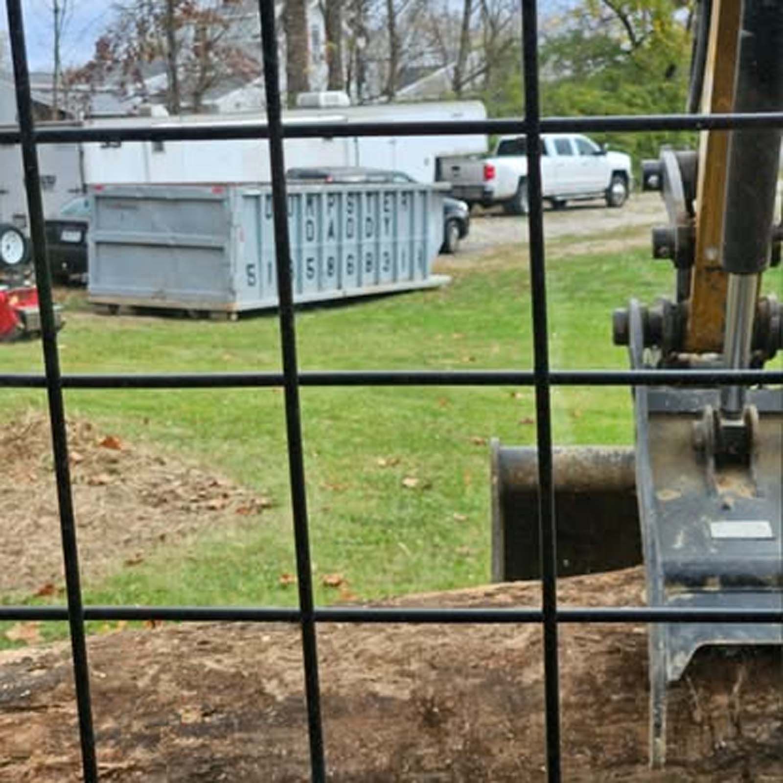 A view of a construction site through a wire fence.