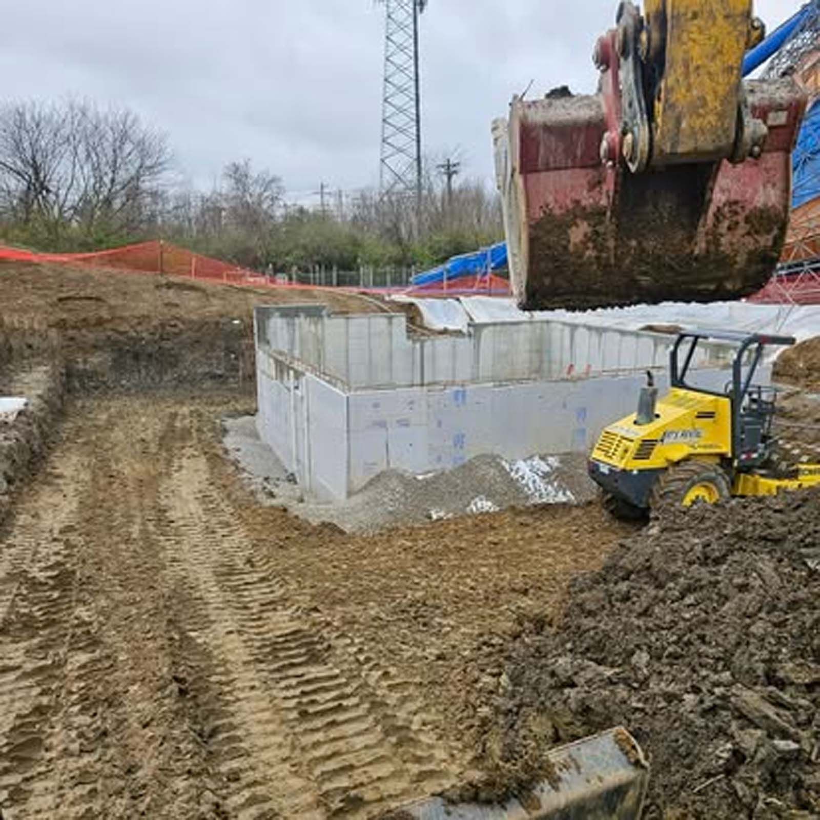 A bulldozer is digging a hole in the dirt in a construction site.