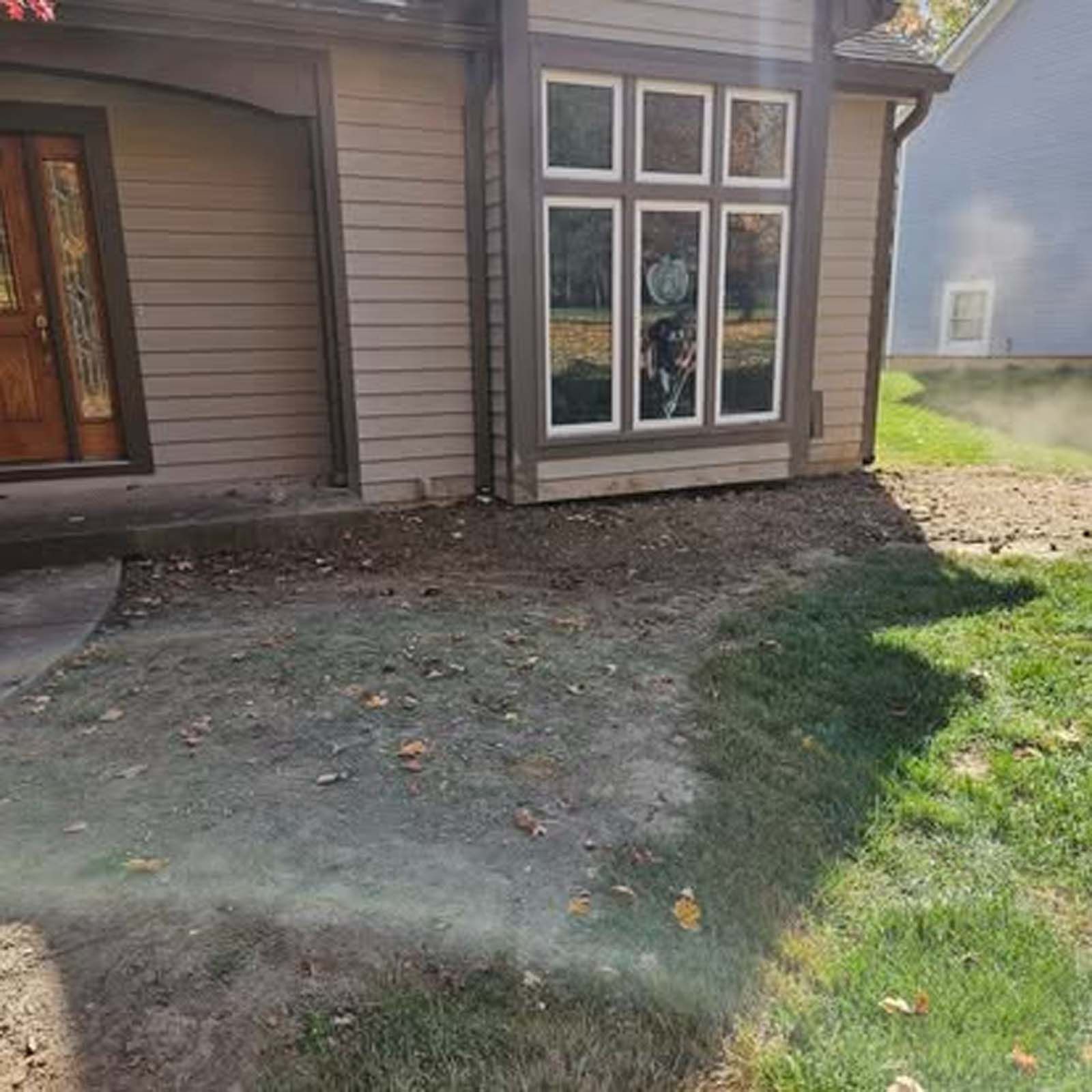 A house with a lot of windows and a lawn in front of it.