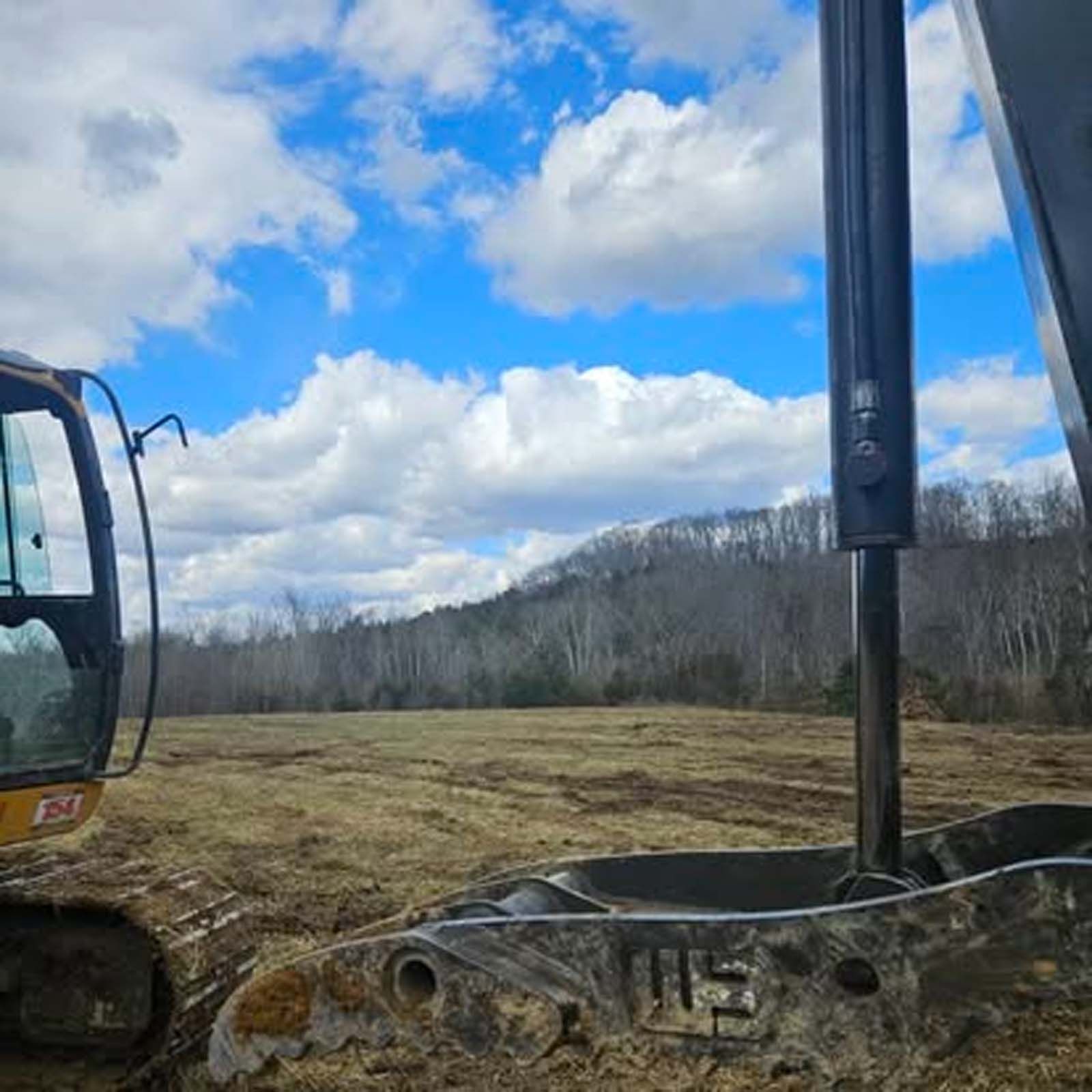A bulldozer is sitting in the middle of a field.