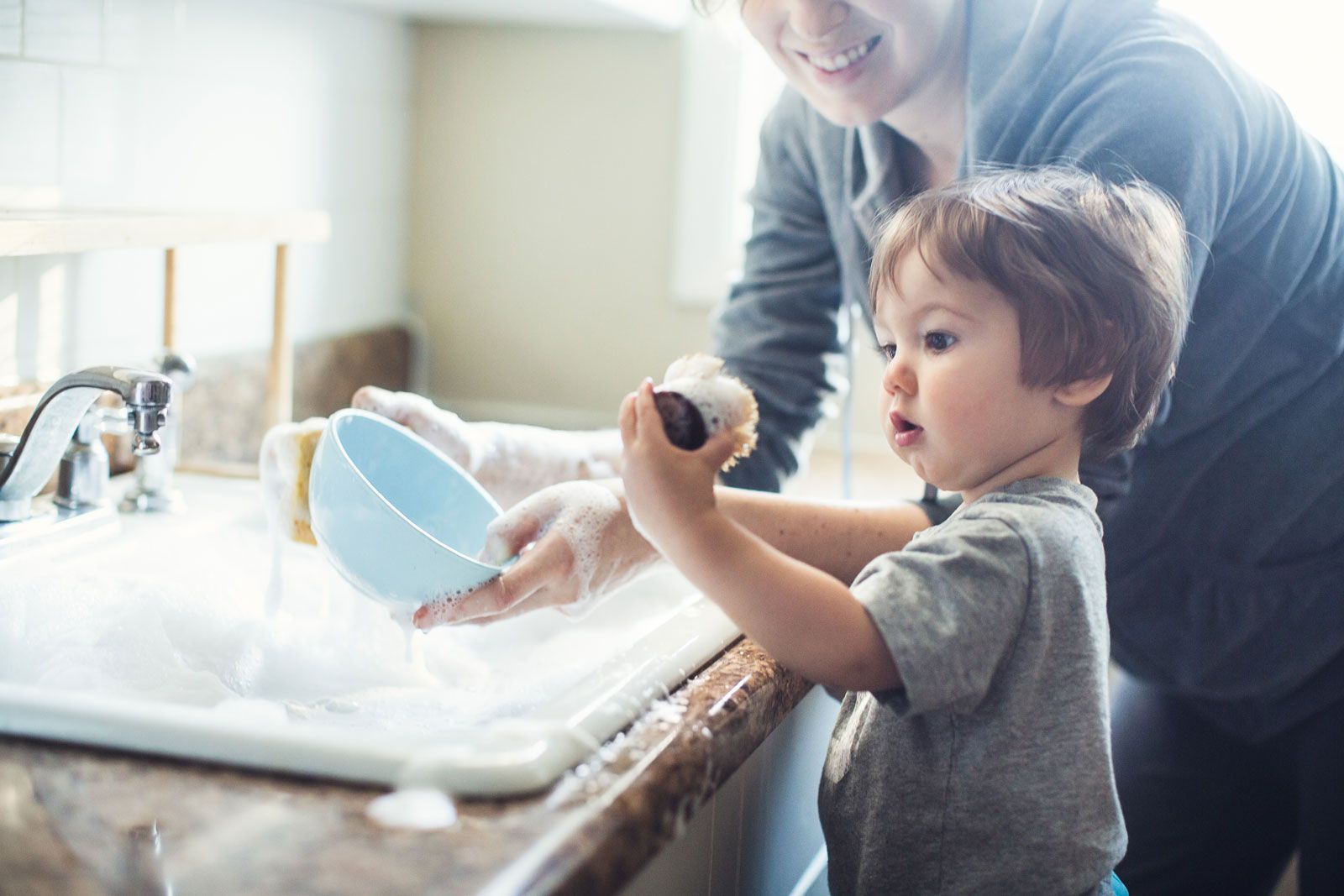 A Cute Toddler Washing The Dishes — Westfield, MA — ASP Plumbing & Heating
