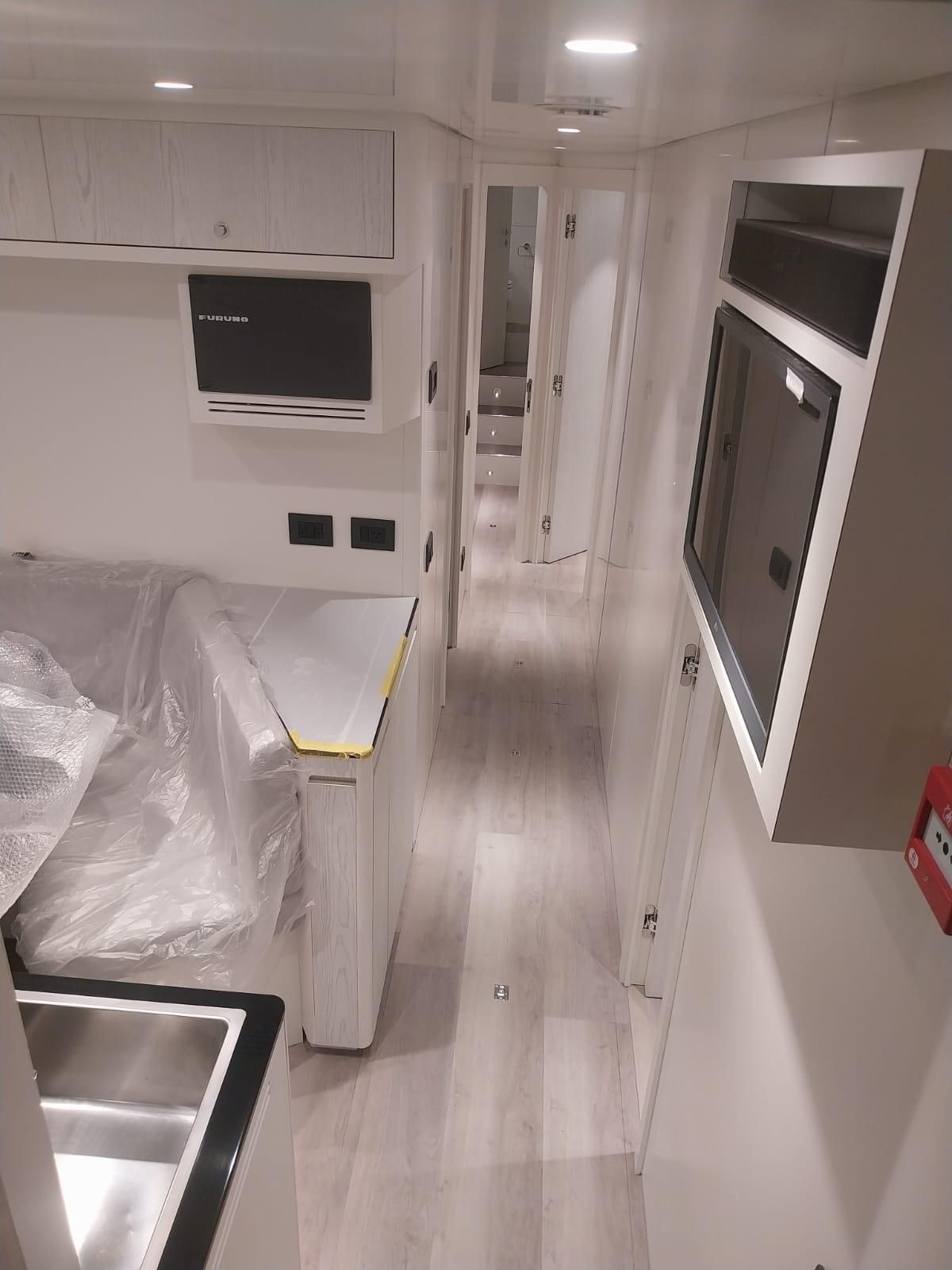 Una cucina con lavello, frigorifero, microonde e televisione.