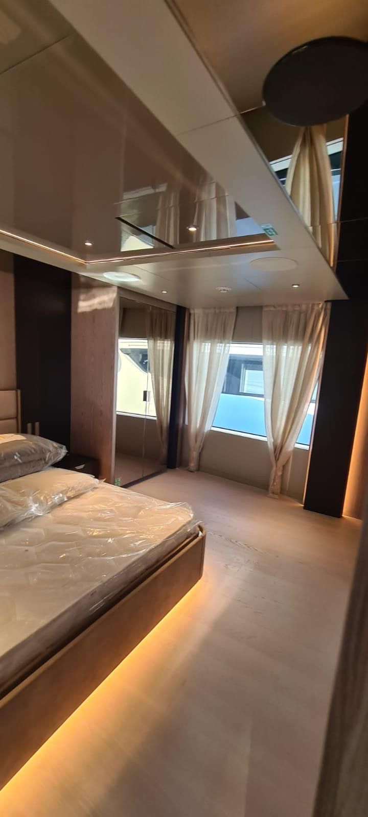 Una camera da letto su una barca con un letto e una finestra.