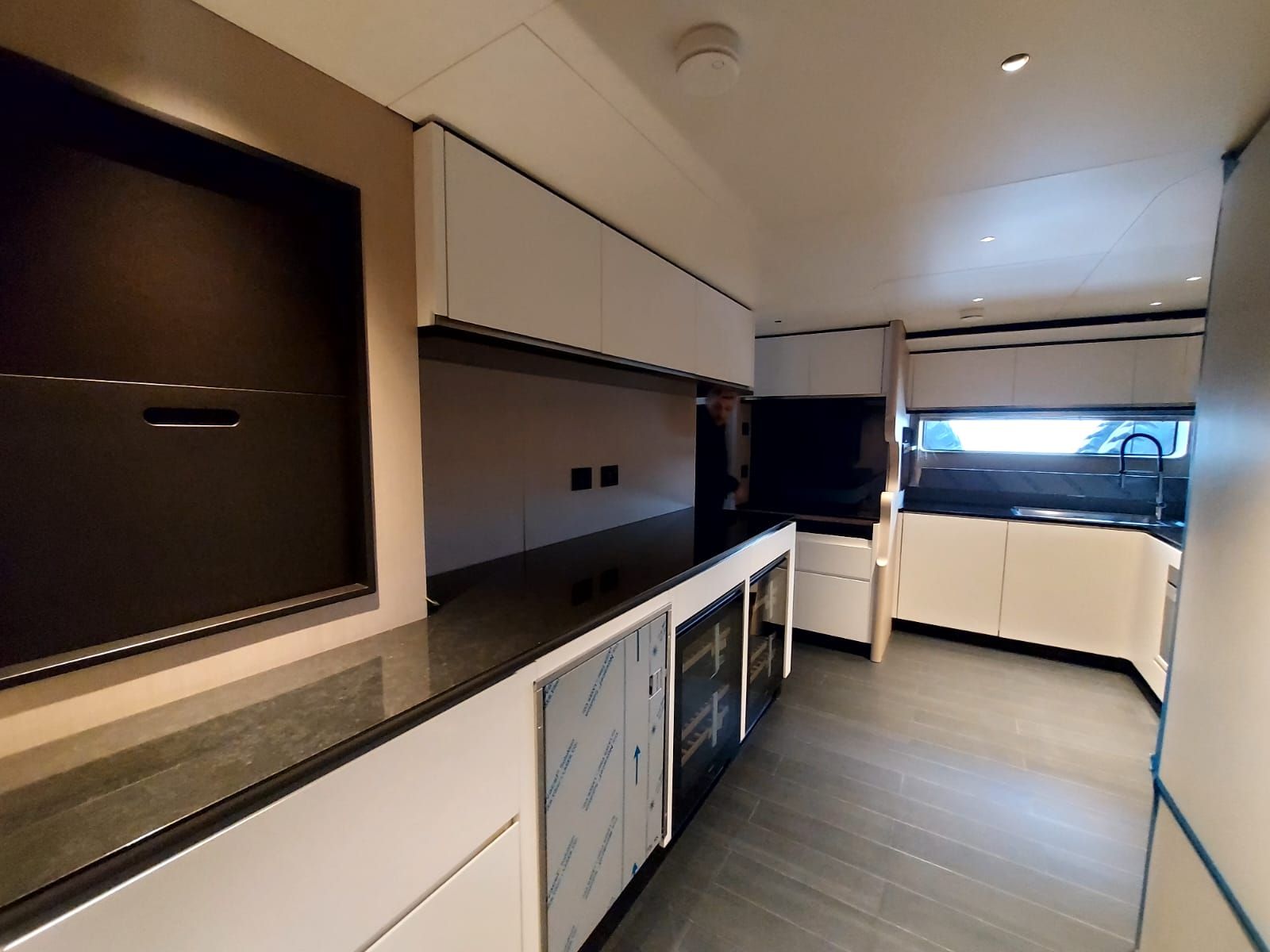 Una cucina con mobili bianchi e ripiani neri