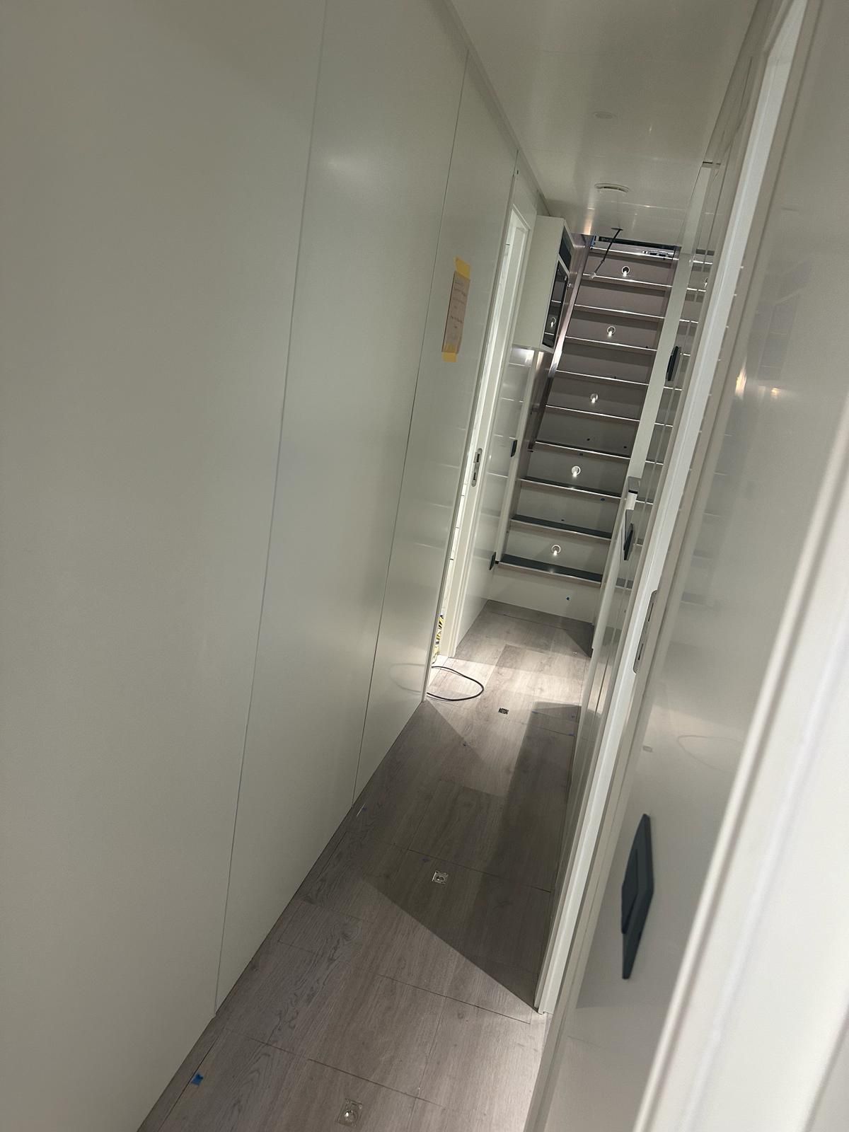 Un corridoio con scale che portano al secondo piano di un edificio.