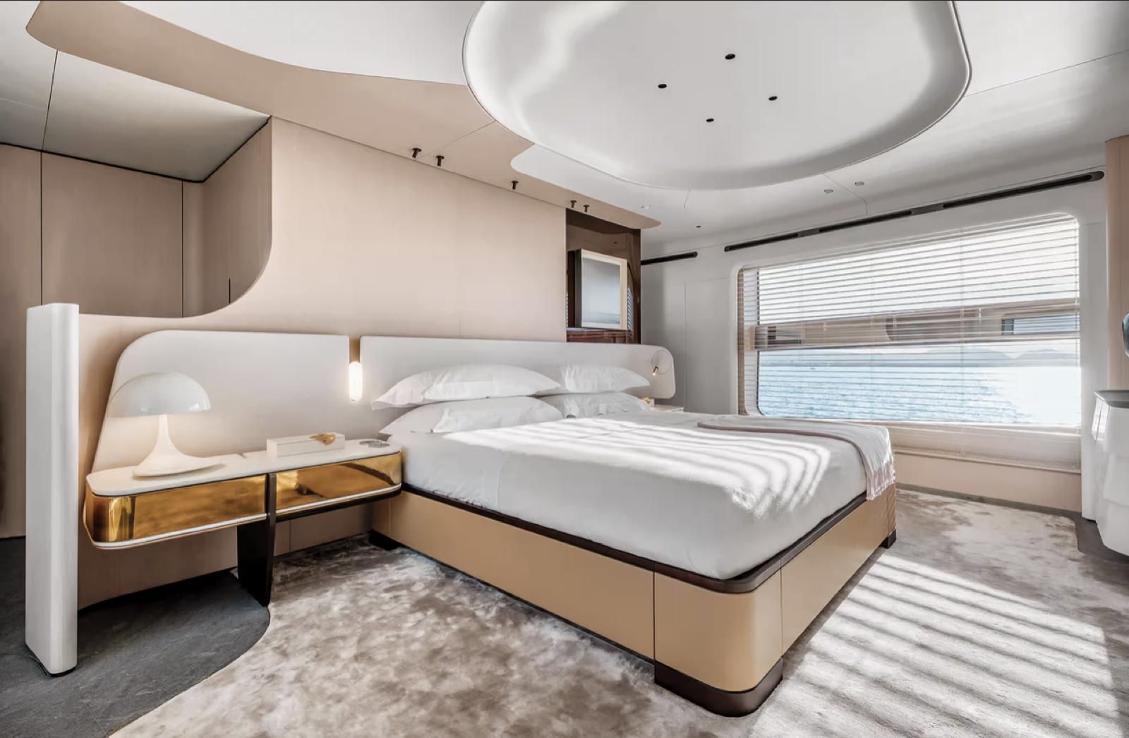 Una camera da letto su uno yacht con un letto grande e una grande finestra.