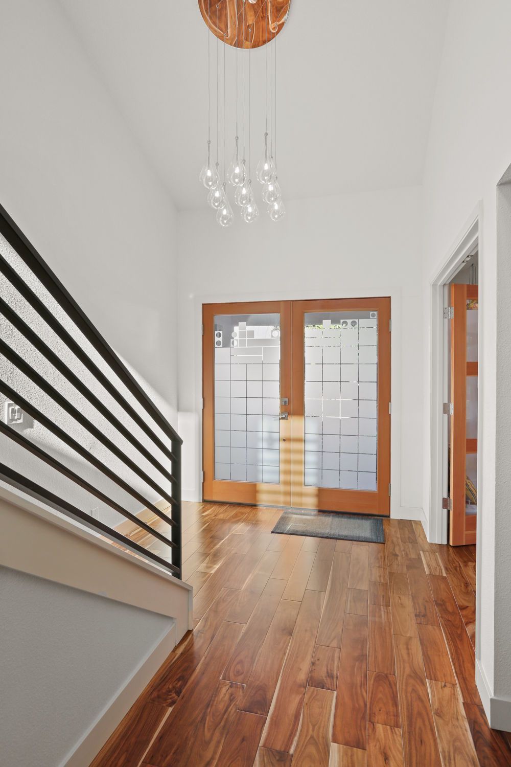 A hallway with hardwood floors and stairs in a house.