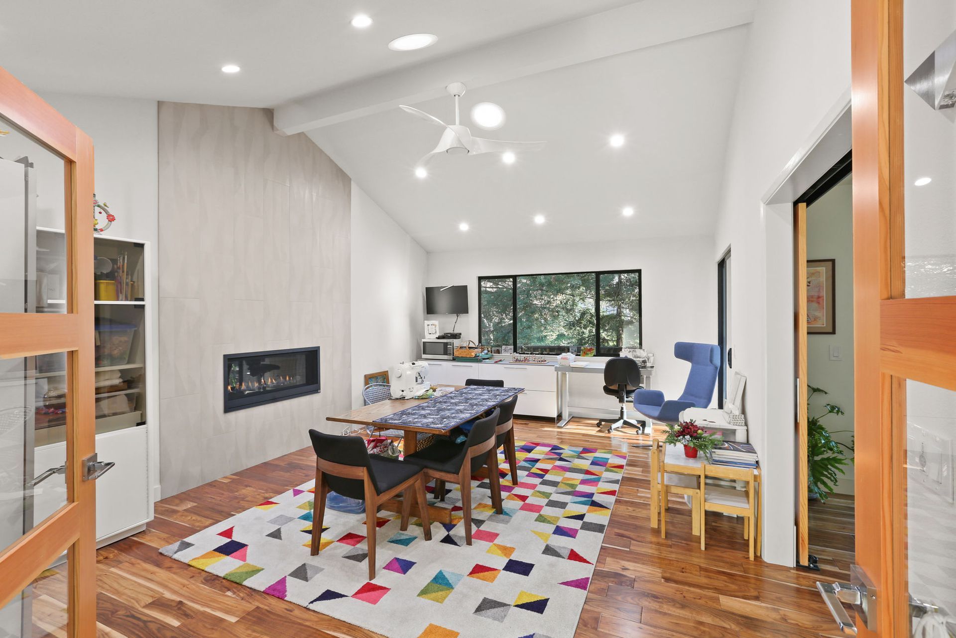 A living room with a colorful rug and a fireplace.