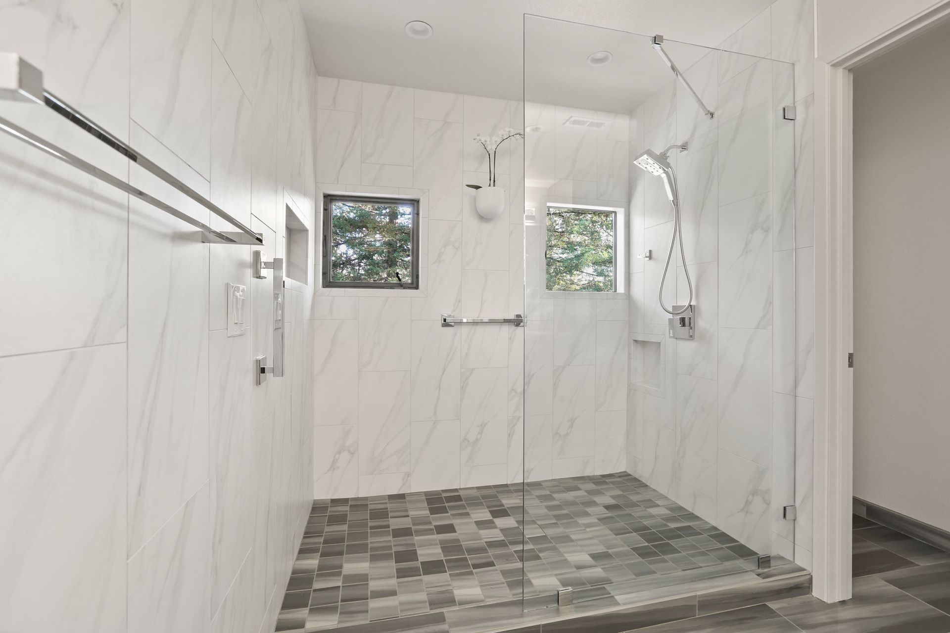 A bathroom with a walk in shower and a window.