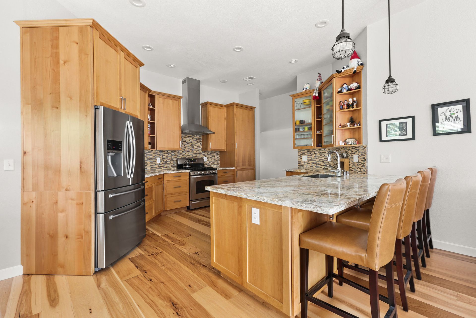 A kitchen with wooden cabinets , granite counter tops , stainless steel appliances and a large island.