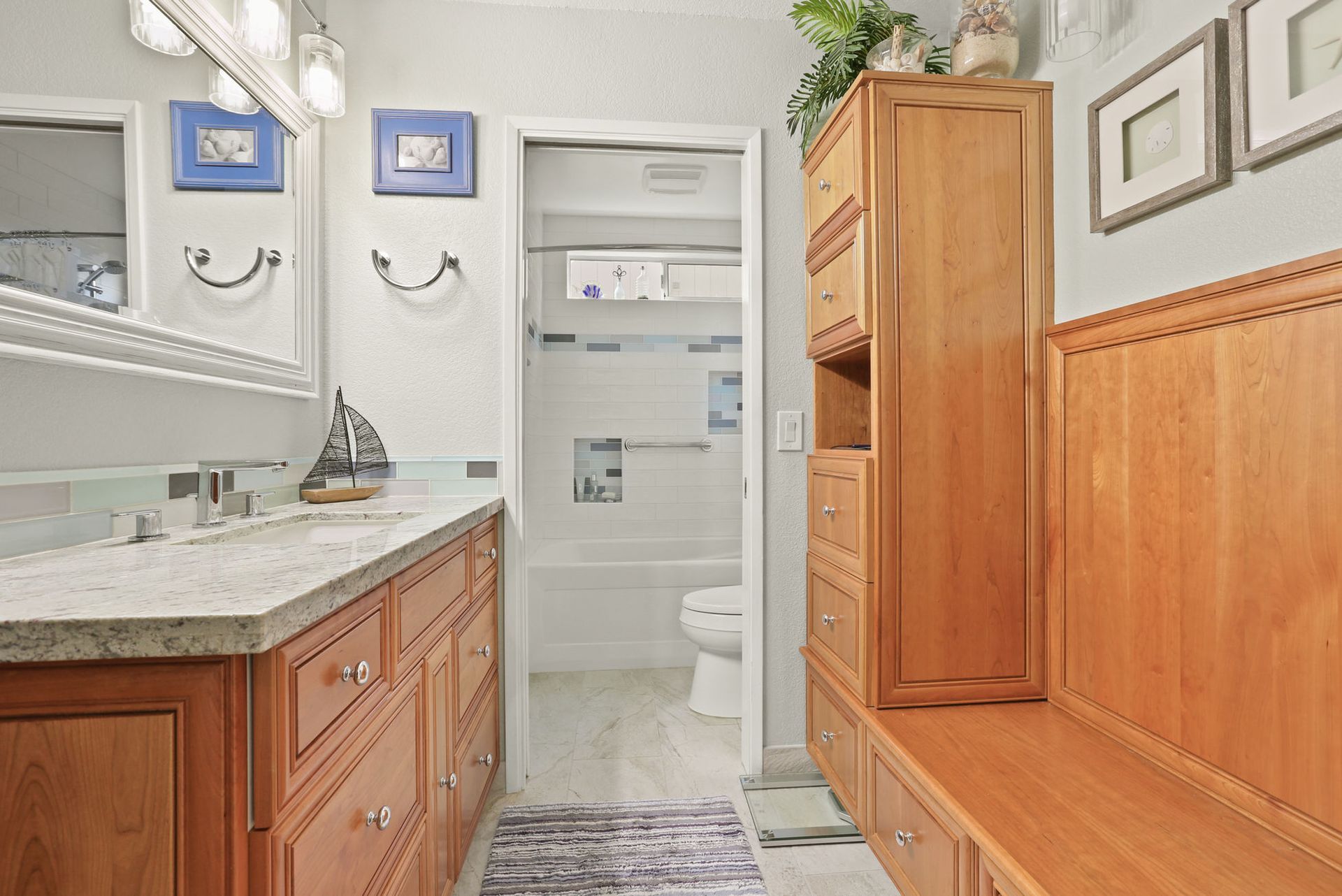 A bathroom with two sinks , a toilet , and a bench.