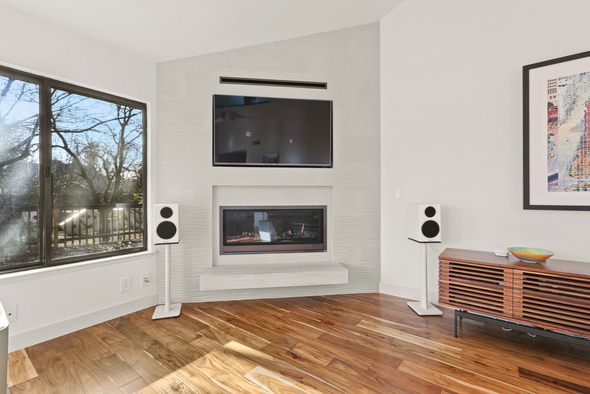 A living room with a fireplace , television and speakers.