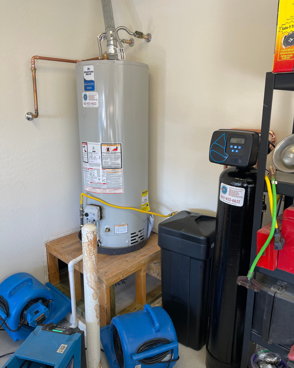 A water heater is sitting on a wooden table in a room.