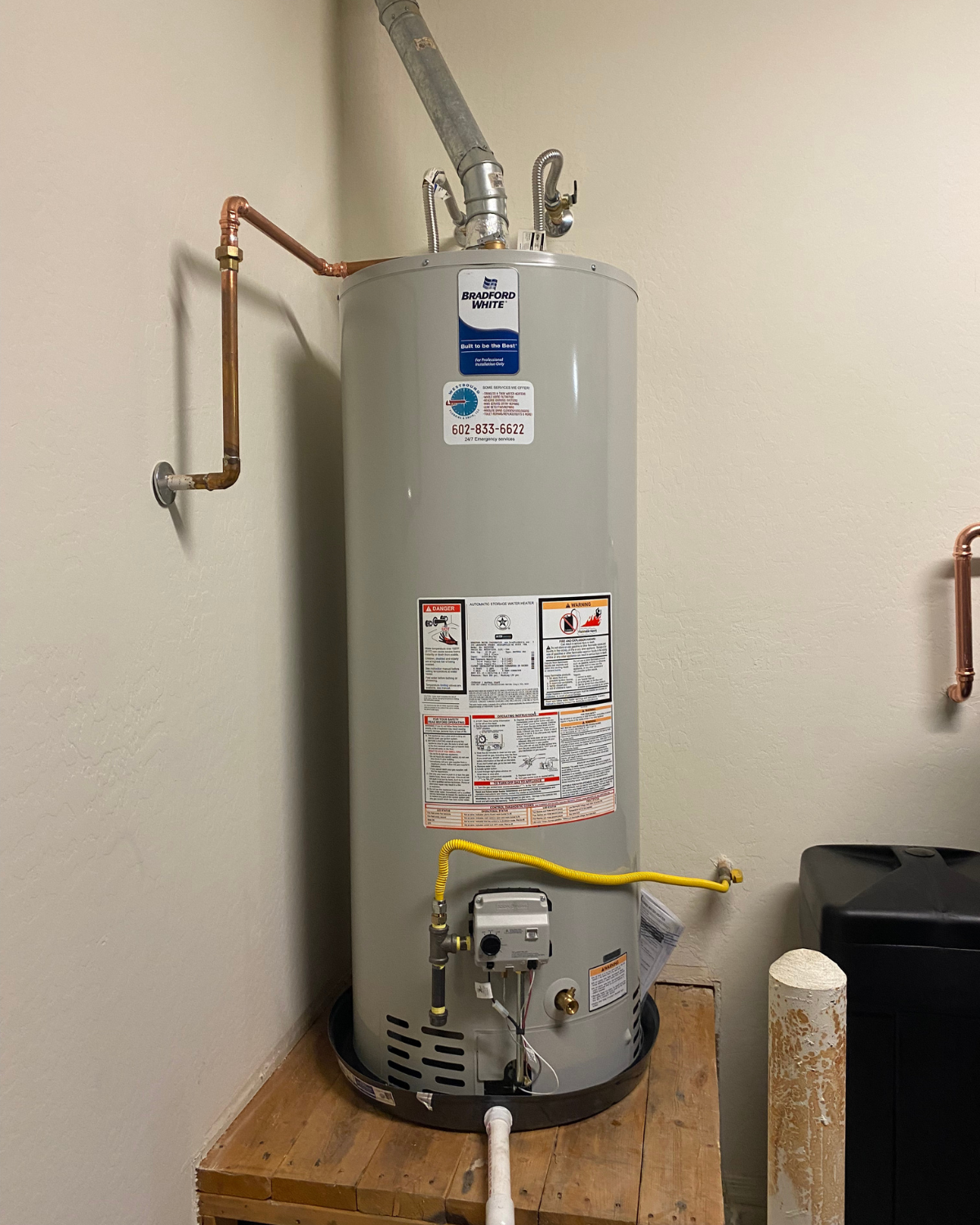 A water heater is sitting on top of a wooden table.