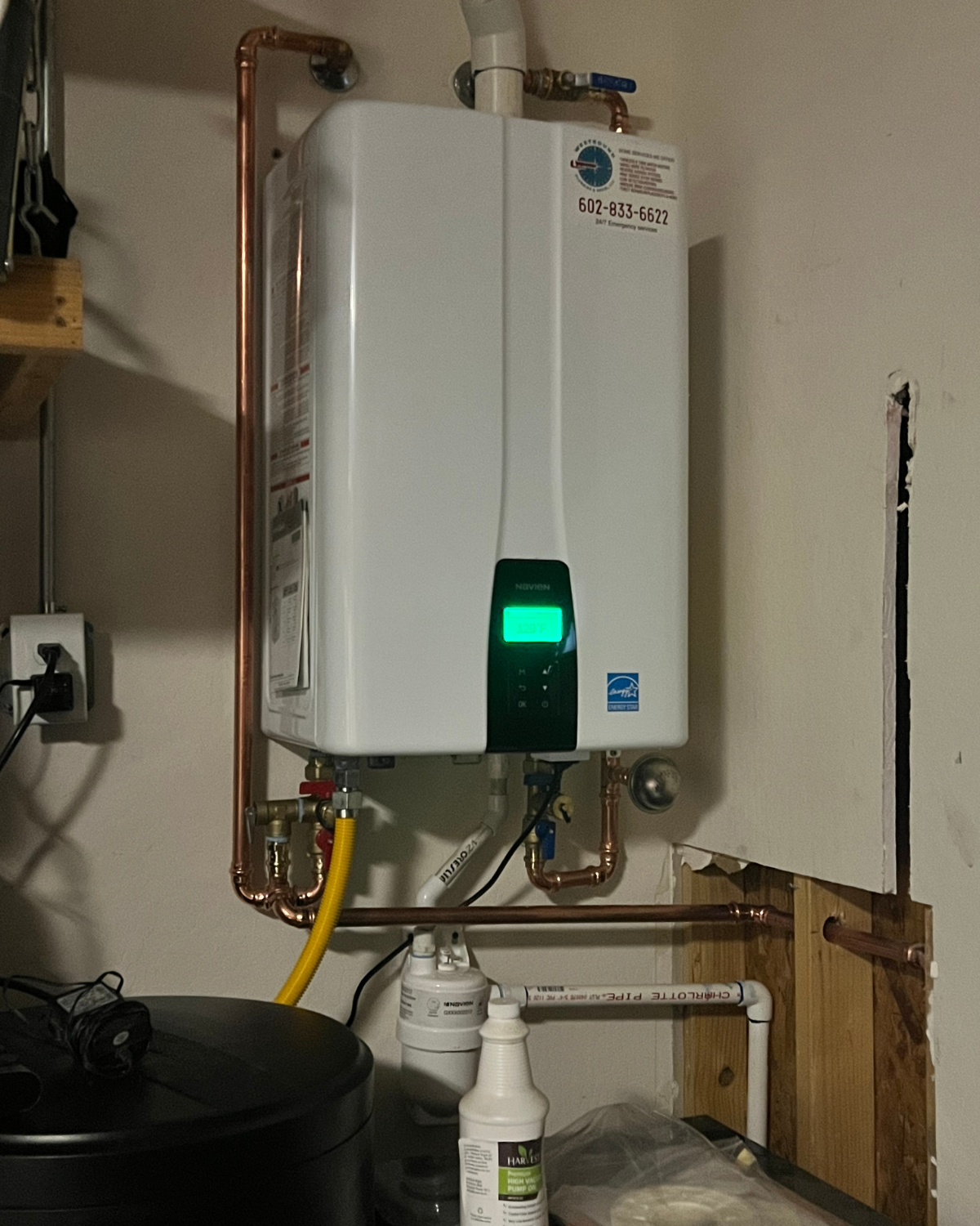 A white water heater is mounted to a wall