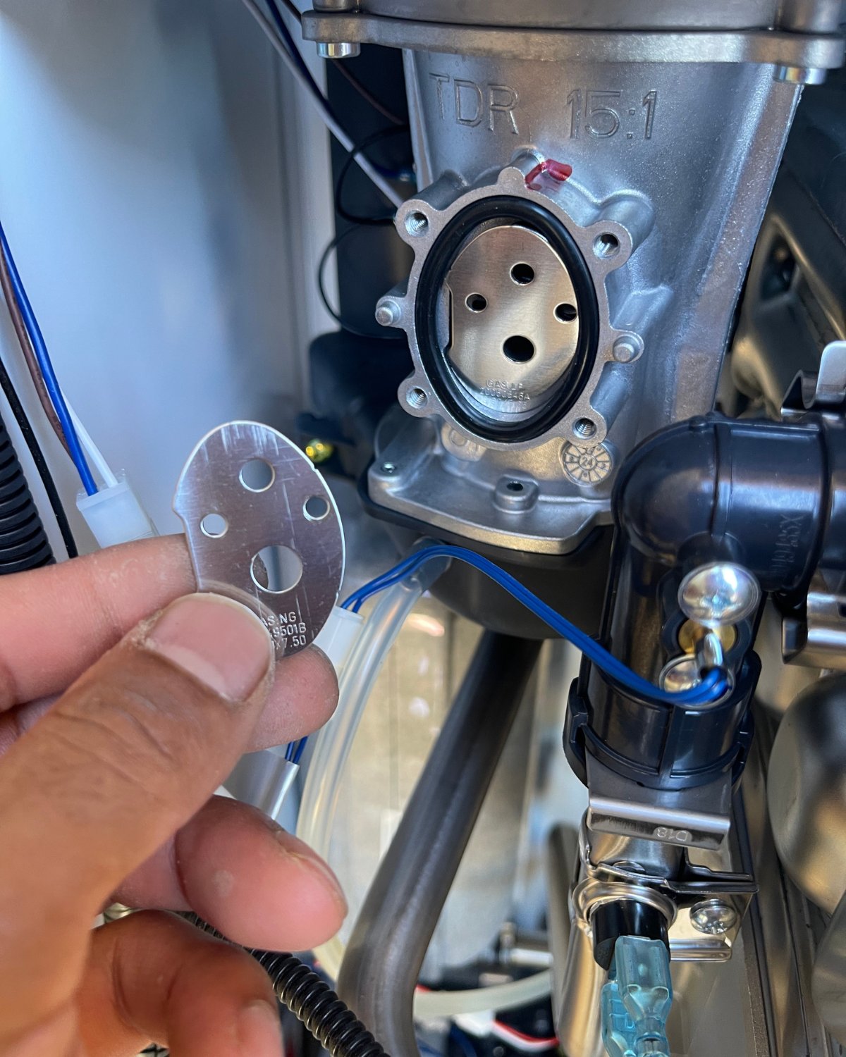 A person is holding a key in front of a machine.