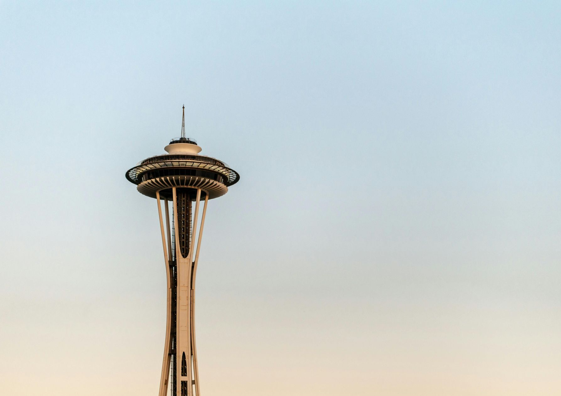 Space Needle, Seattle, rises into a pale blue sky.