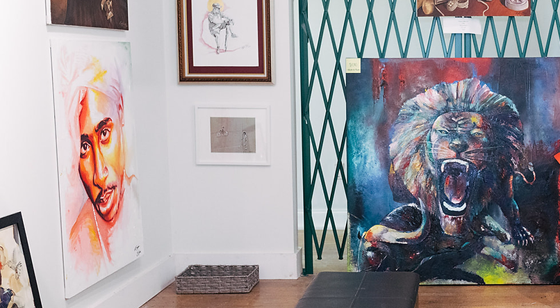 A room filled with paintings and a lion painting on the wall.