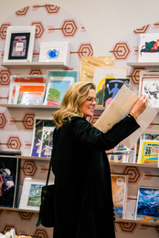 A woman is looking at a book in a bookstore.
