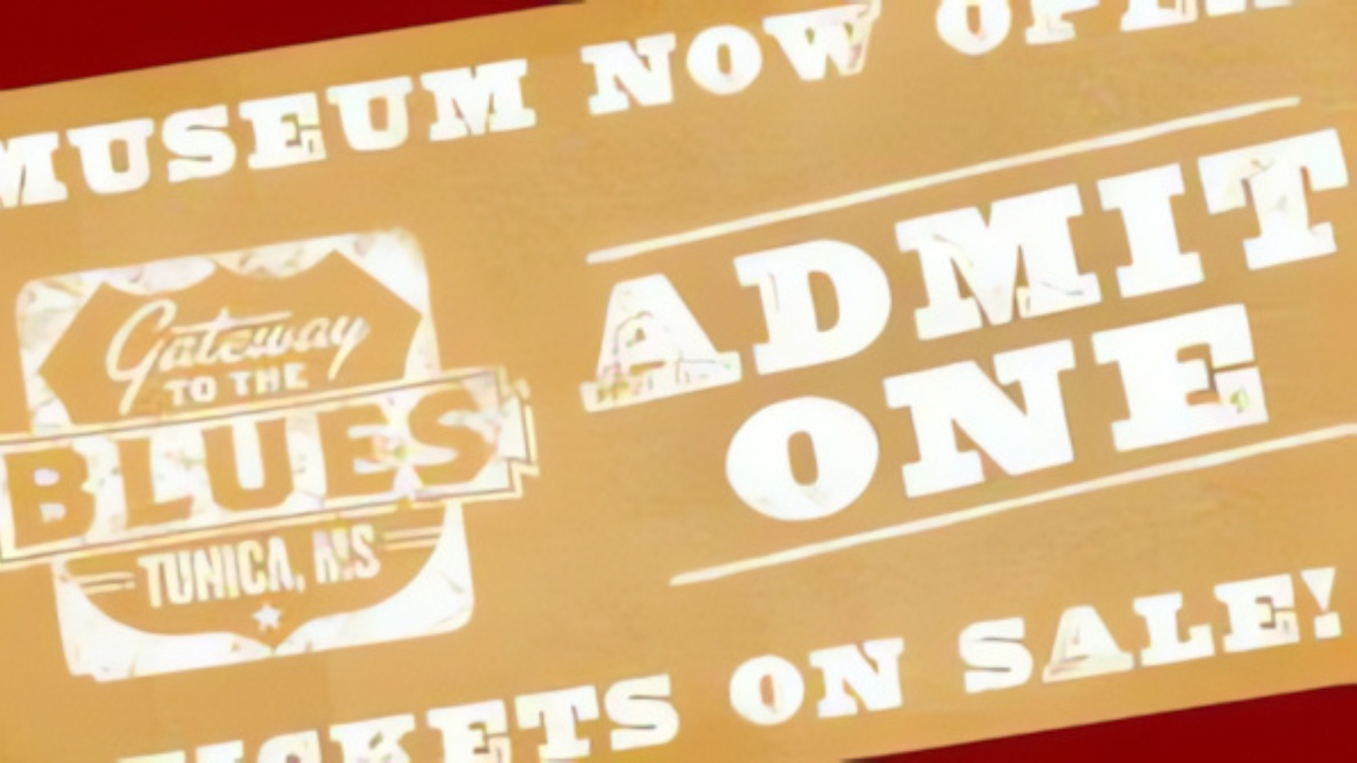 A brown sign that says museum now open and admit one