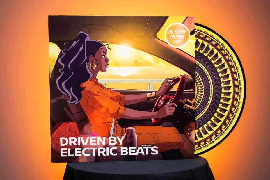 A woman is driving a car with the words `` driven by electric beats '' on the cover.