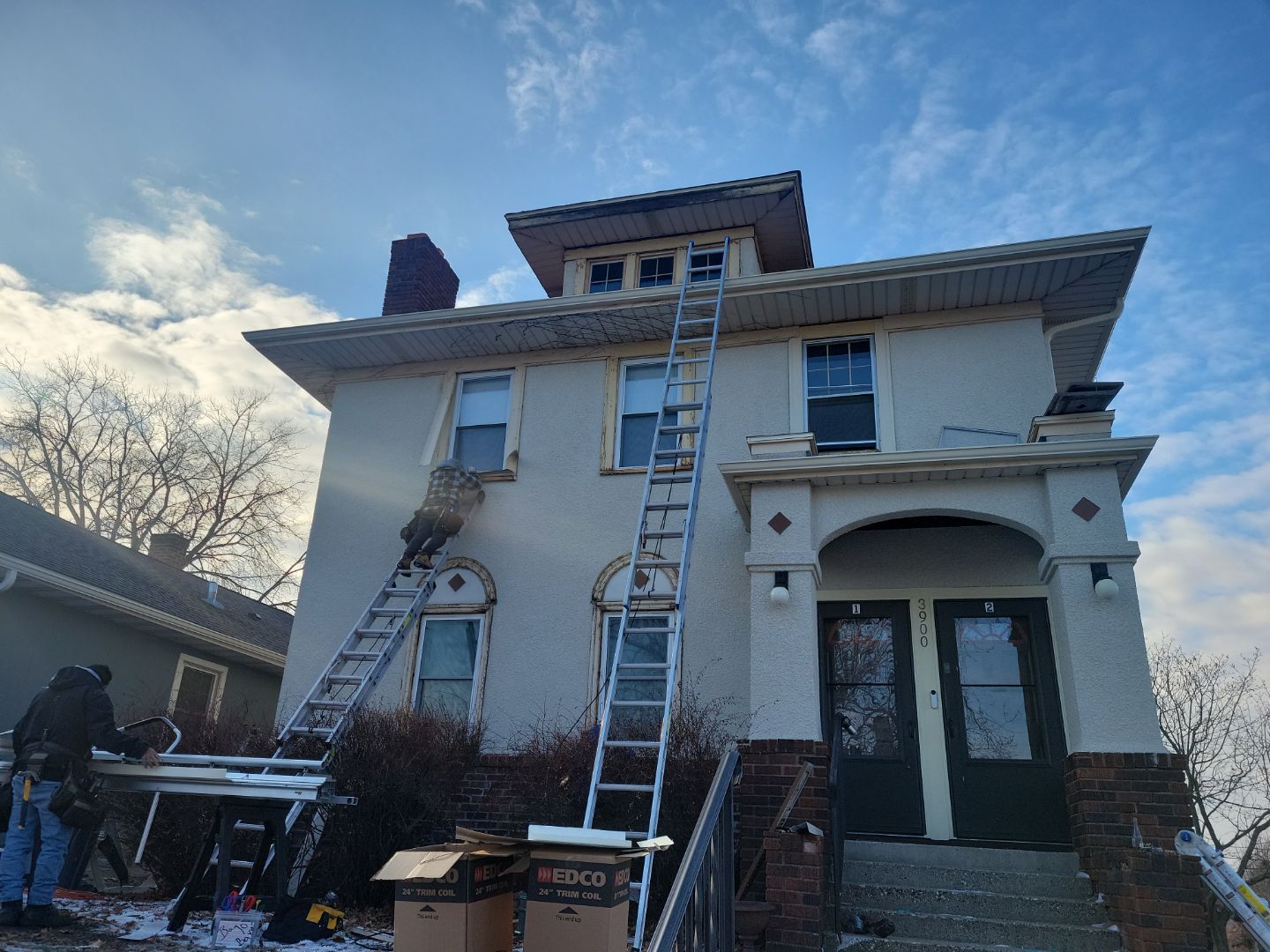 a large white house with a ladder on the side of it .