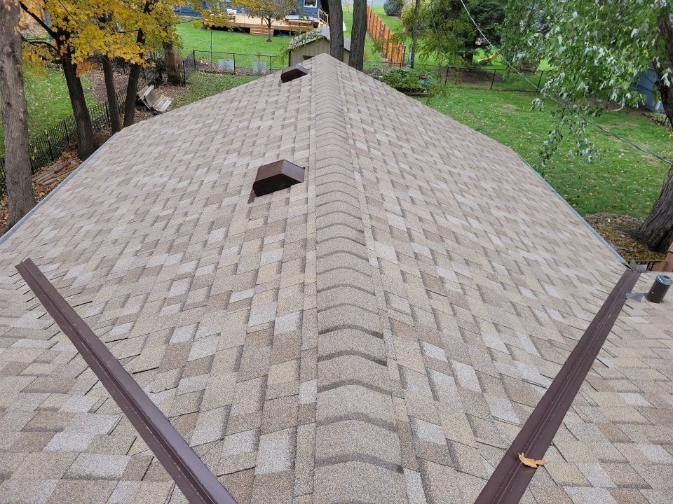 a brick deck with a fence and a tree in the background .