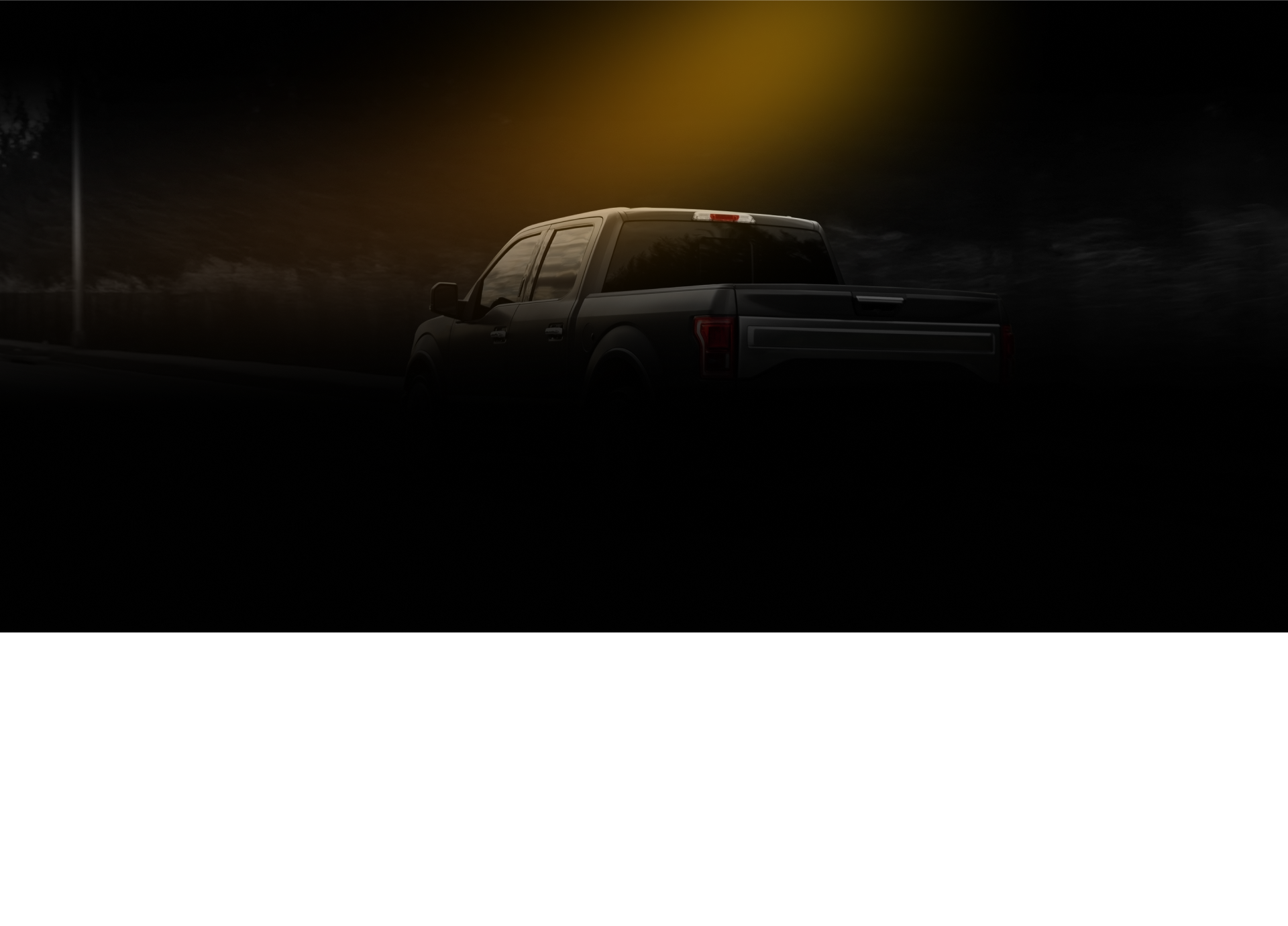 Pickup truck under street light at night.