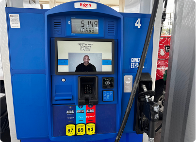 Blue Exxon gas pump with a man on the screen, showing price and fuel options.