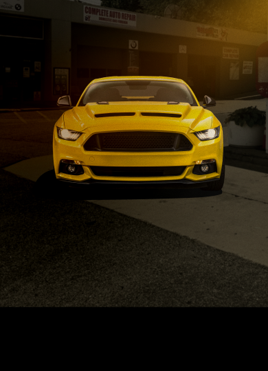 Yellow sports car parked at night.
